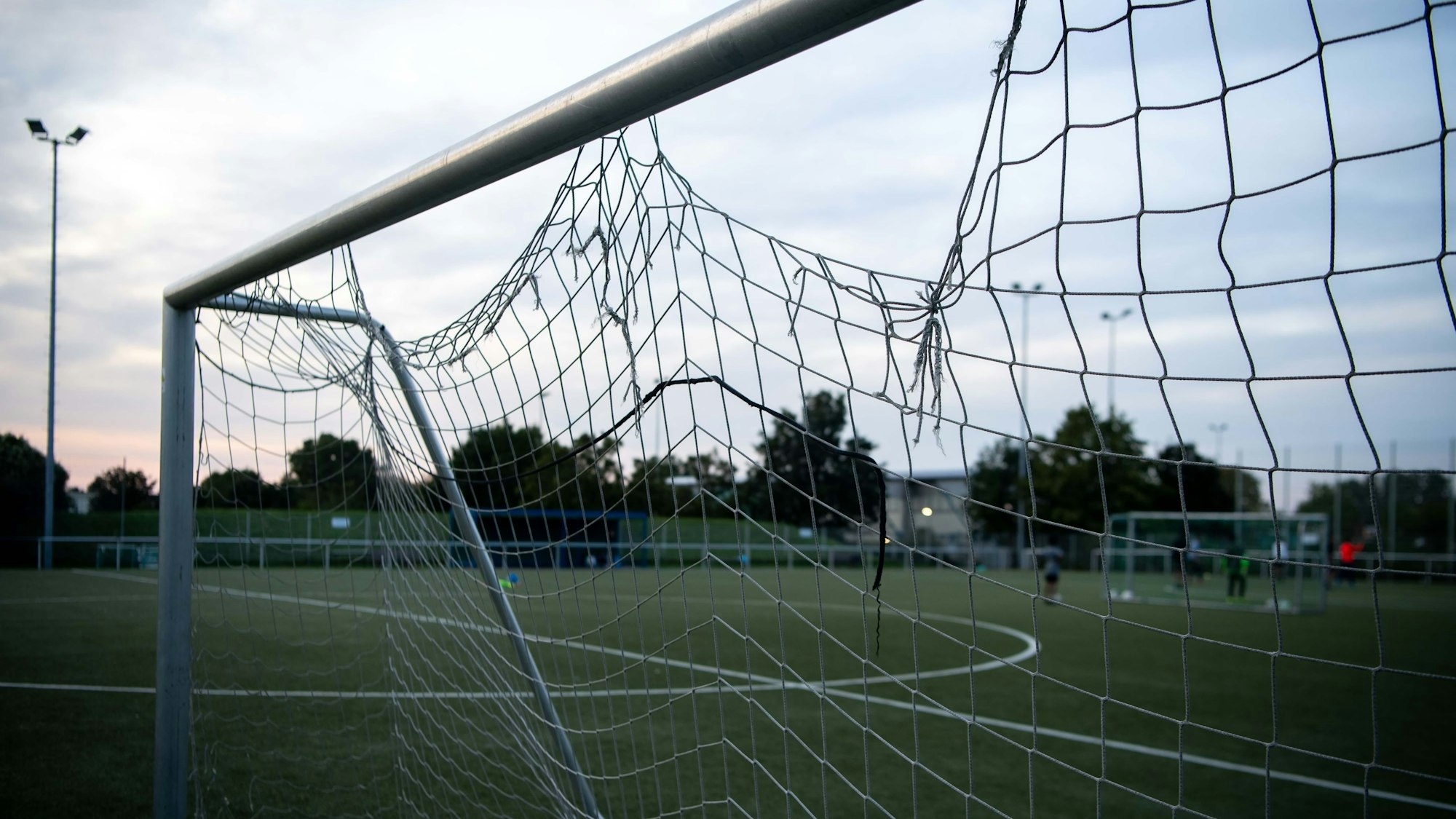 Das Bild zeigt ein Fußballtor, in dem das Netz gleich an mehreren Stellen kaputt ist.