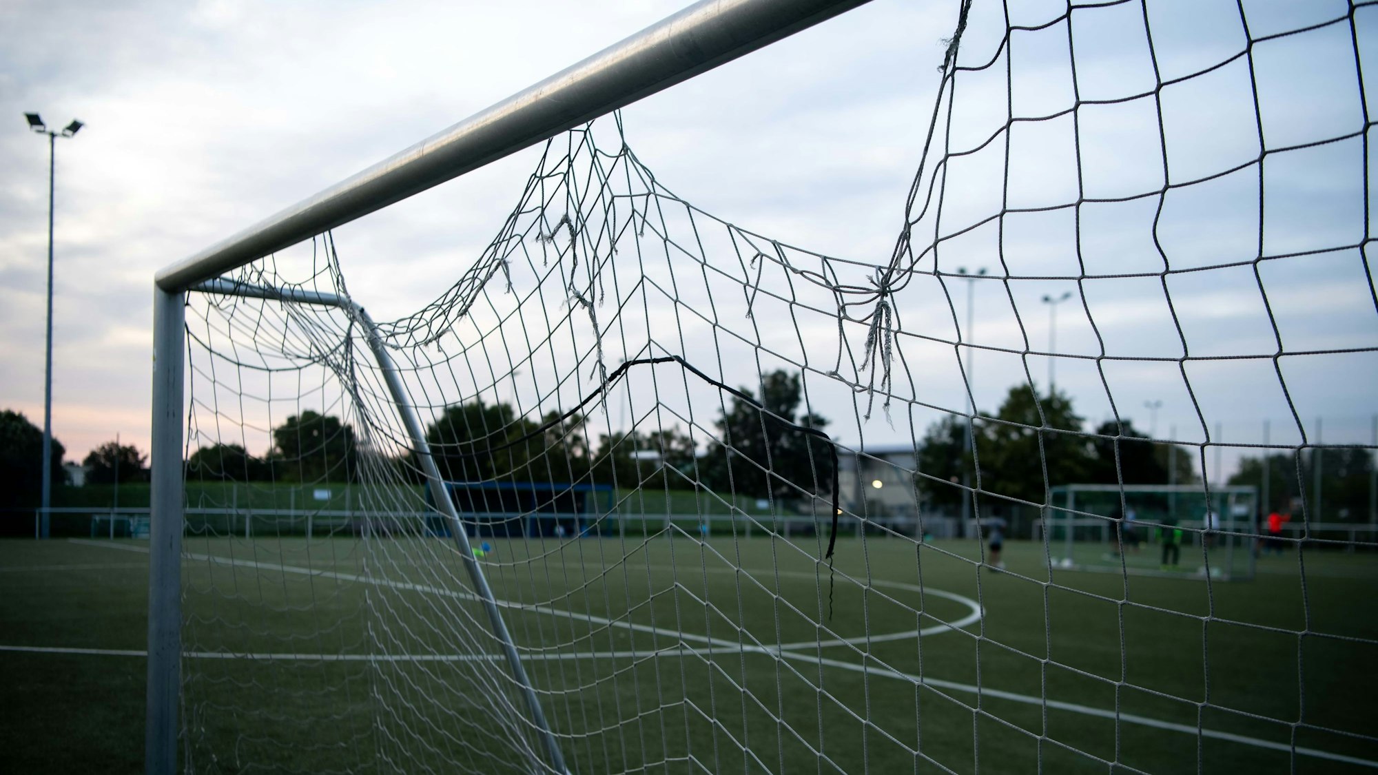 Das Bild zeigt ein Fußballtor, in dem das Netz gleich an mehreren Stellen kaputt ist.