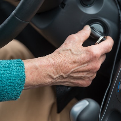 Eine Rentnerin startet mit dem Zündschlüssel ihr Auto.