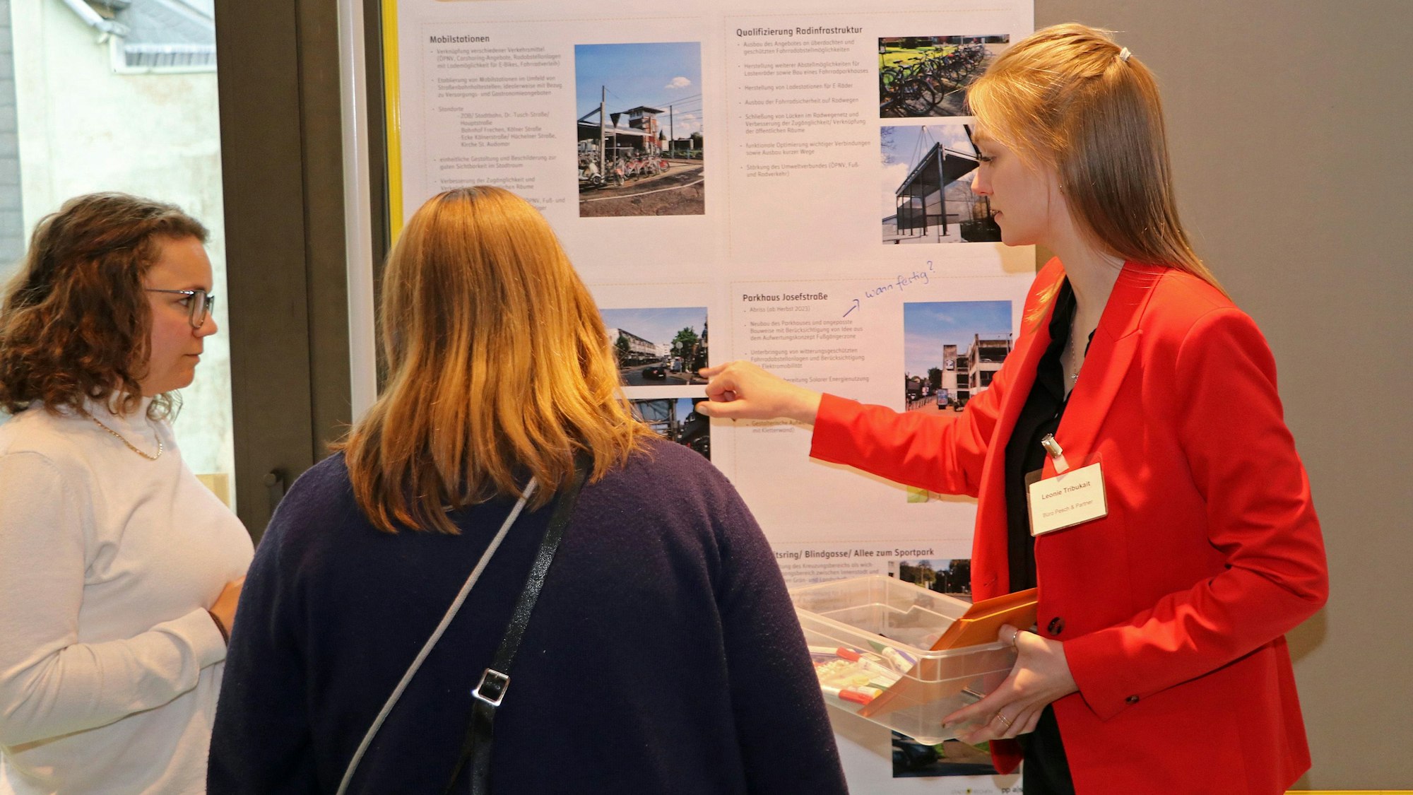 Das Foto zeigt Teilnehmer der Veranstaltung. Sie diskutieren an Schautafeln über verschiedene Projekte zur Verschönerung der Frechener Innenstadt.