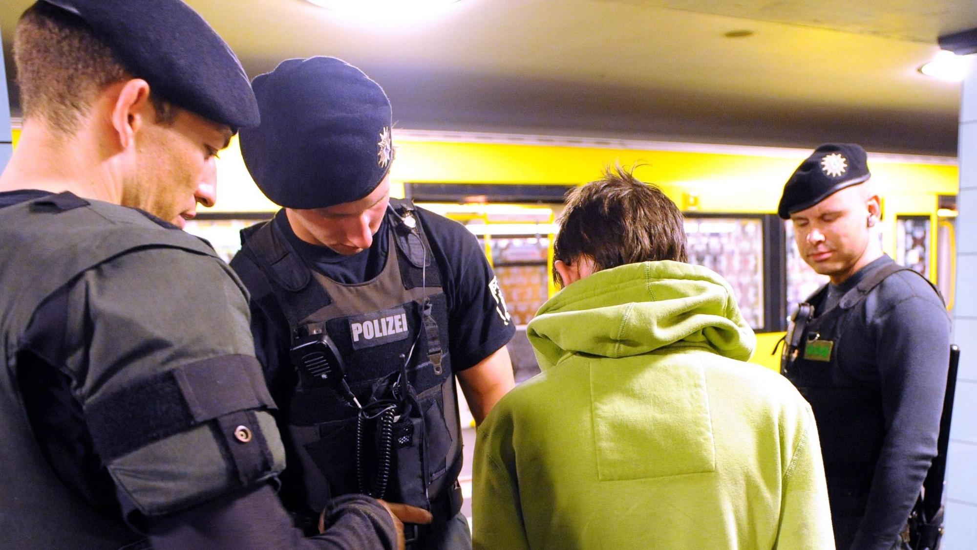 Polizeibeamte durchsuchen einen verdächtigen jungen Mann