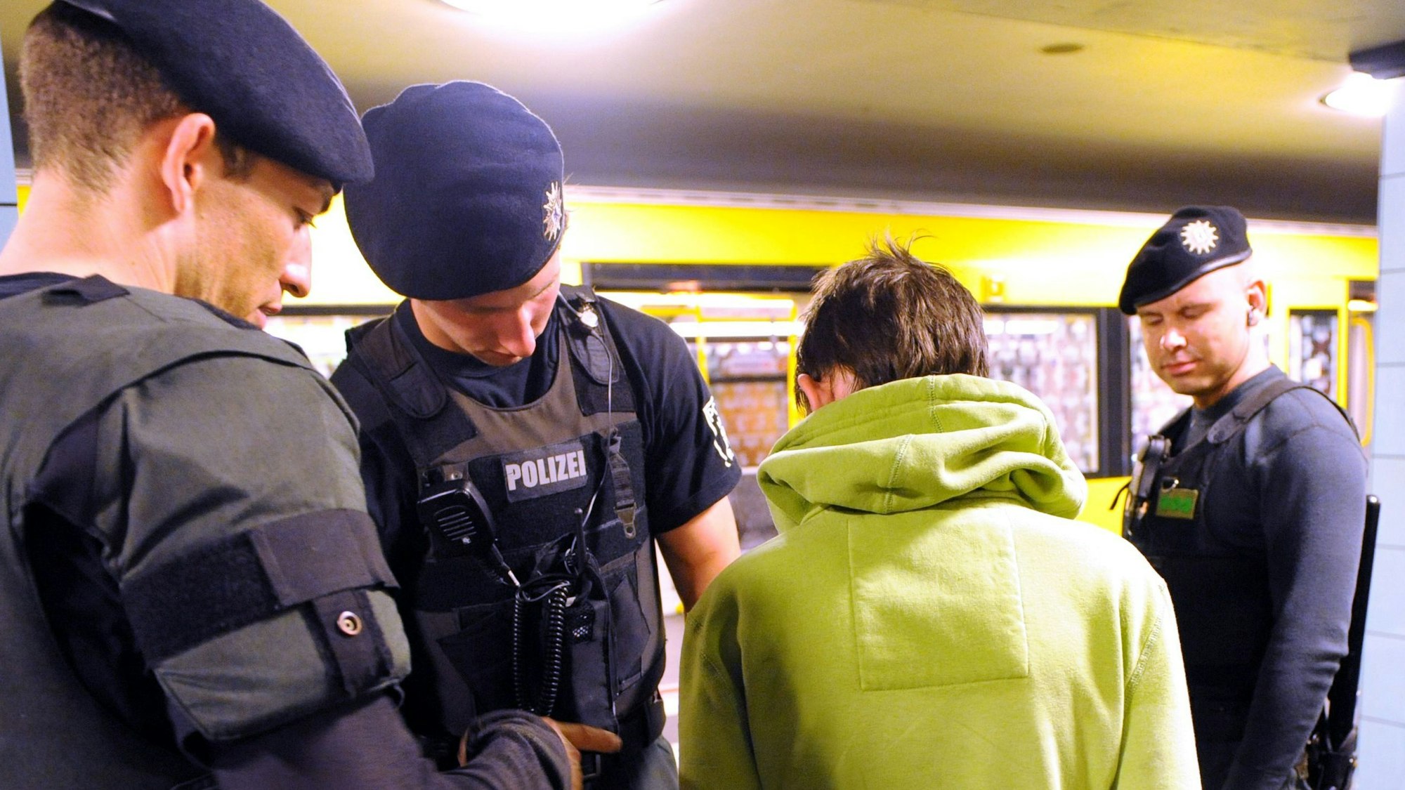 Polizeibeamte durchsuchen einen verdächtigen jungen Mann