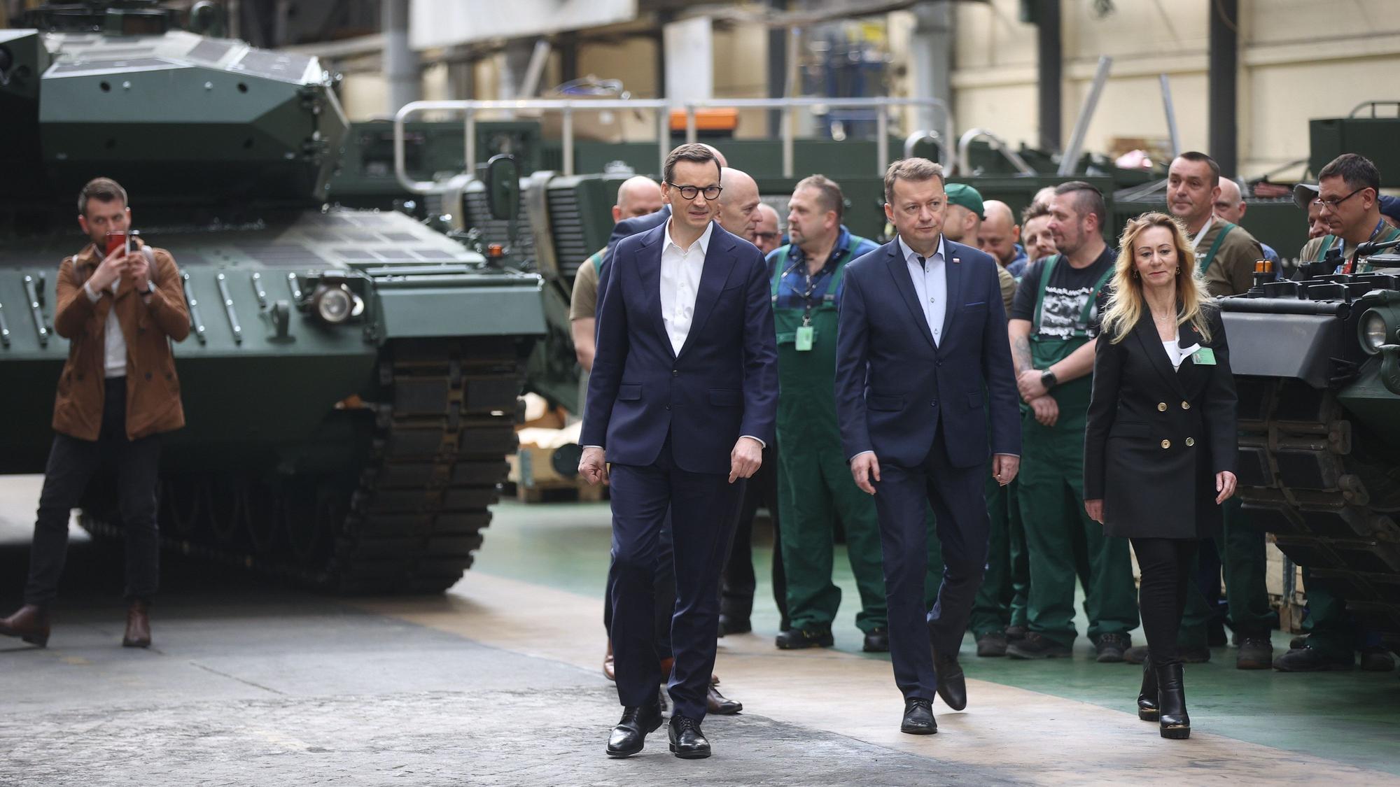 Mateusz Morawiecki, Ministerpräsident von Polen, Mariusz Blaszczak, stellvertretende Ministerpräsident und Verteidigungsminster in Polen, und Edyta Szymanska, Vorstandsvorsitzende der Mechanischen Werke Bumar-Labedy, gehen während des Besuchs bei dem Rüstungshersteller Bumar-Labedy.