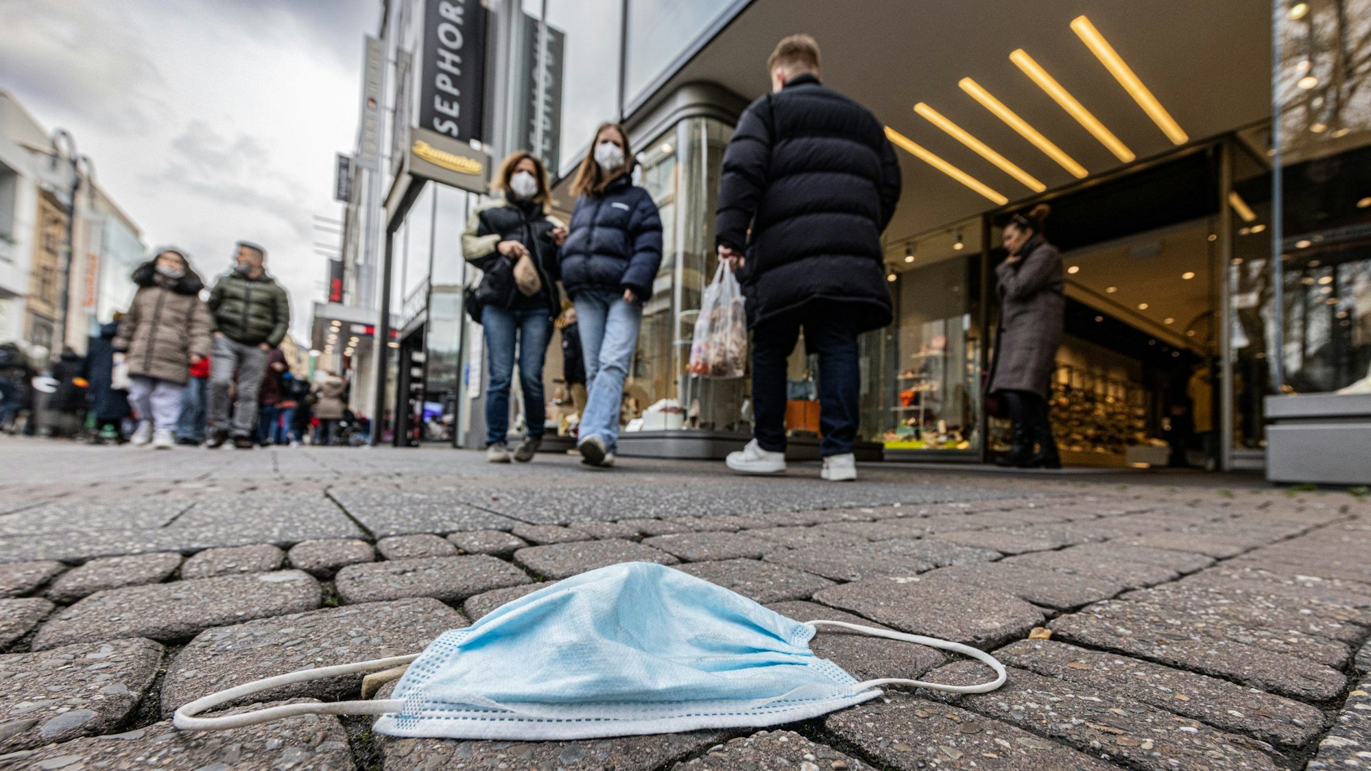 Eine Maske wie diese sorgte auf dem Heumarkt in Köln für einen Streit. Eine Maske liegt auf der Straße. (Symbolbild)