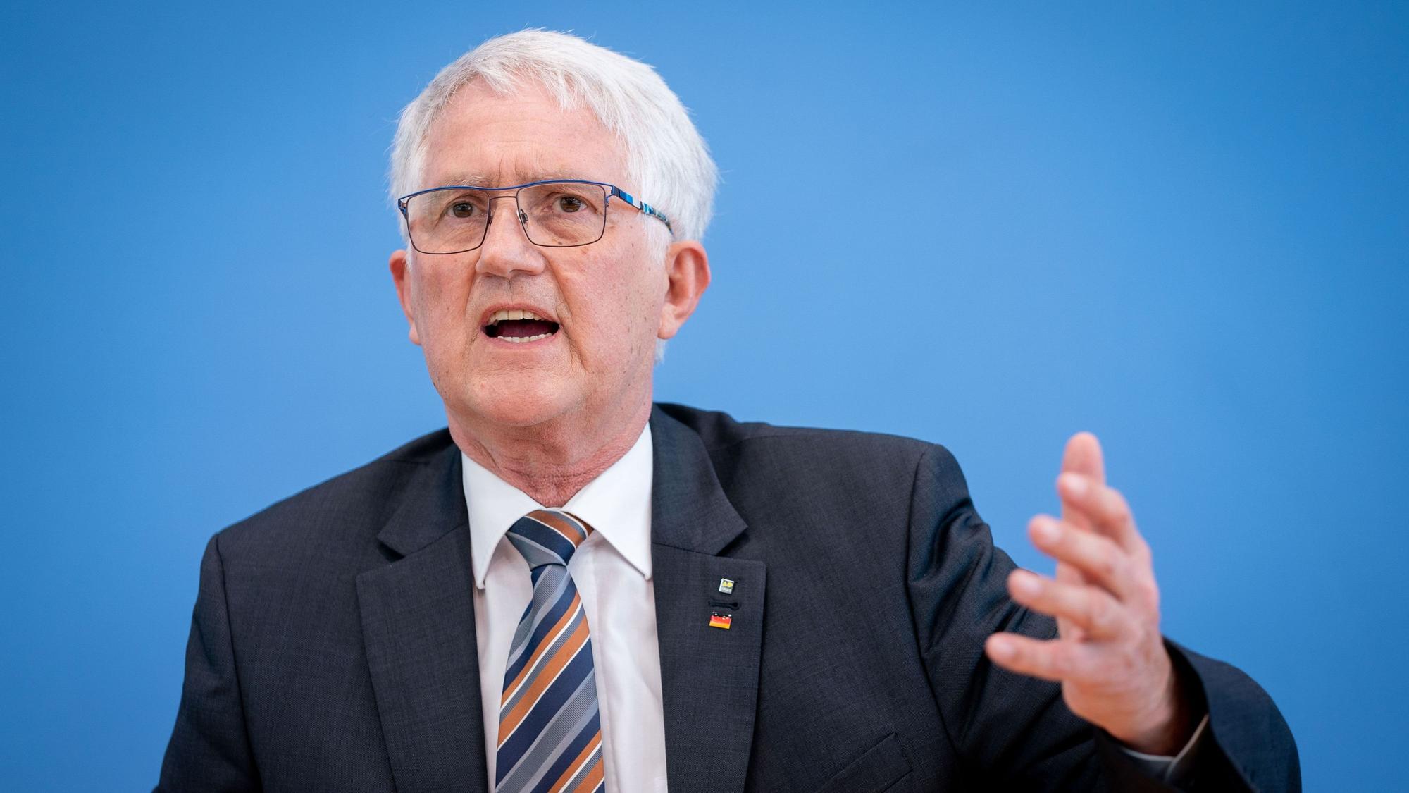 Georg Schirmbeck, Präsident des Deutschen Forstwirtschaftsrates, steht vor einer blauen Wand und gestikuliert.
