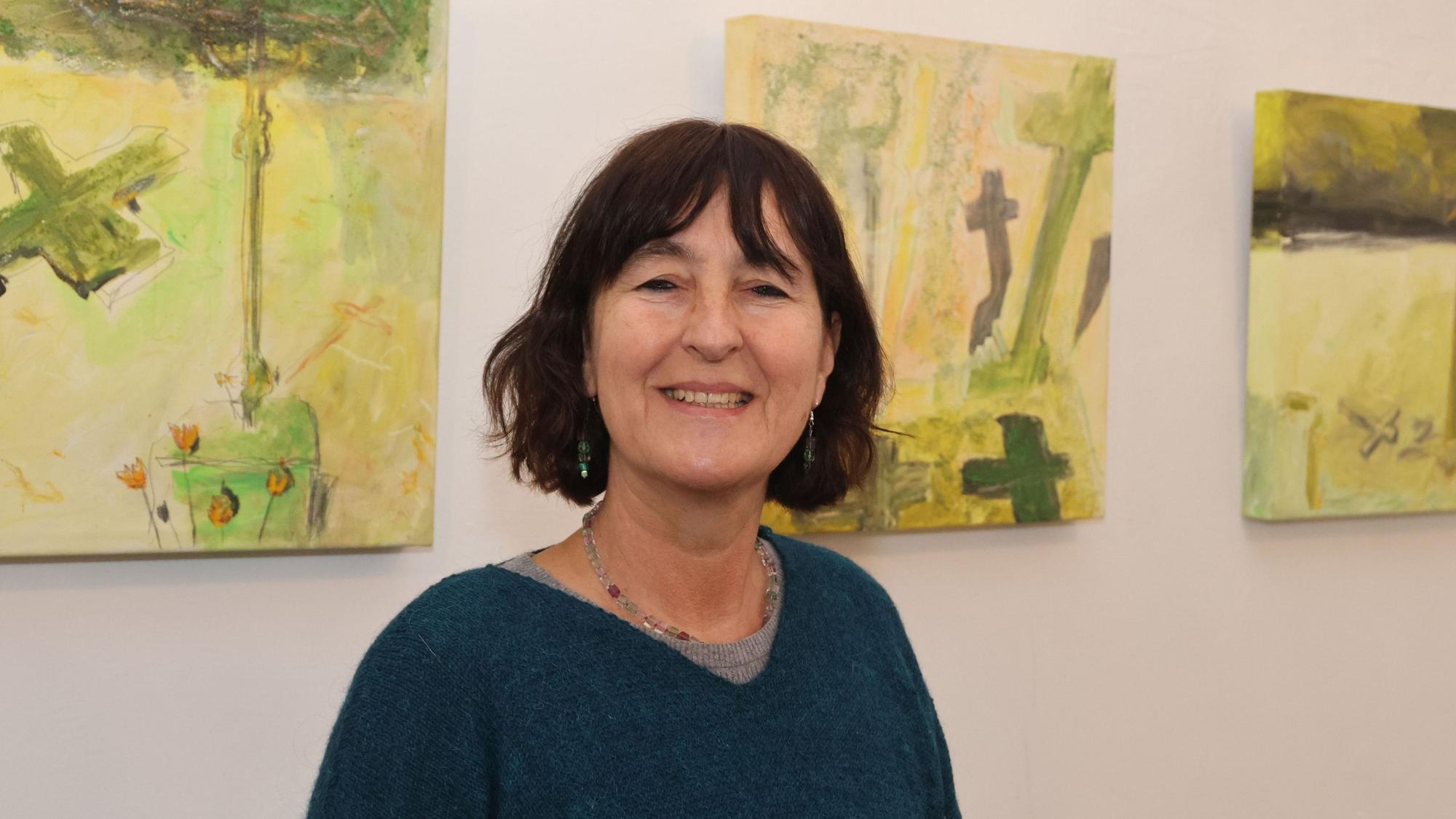 Die Reichshofer Künstlerin steht vor Bildern ihrer Ausstellung.