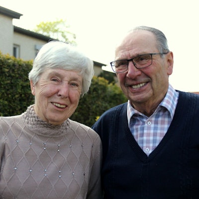 Das Ehepaar blickt lachend in die Kamera.