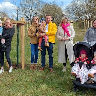 Mehere Familien stehen mit Bürgermeisterin Jennifer Meuren (2.v.r.) auf der Neubürgerbaumwiese.