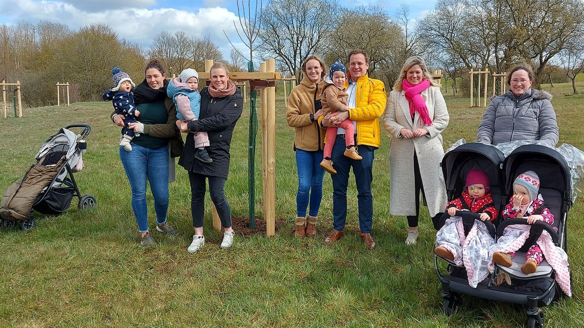 Mehere Familien stehen mit Bürgermeisterin Jennifer Meuren (2.v.r.) auf der Neubürgerbaumwiese.