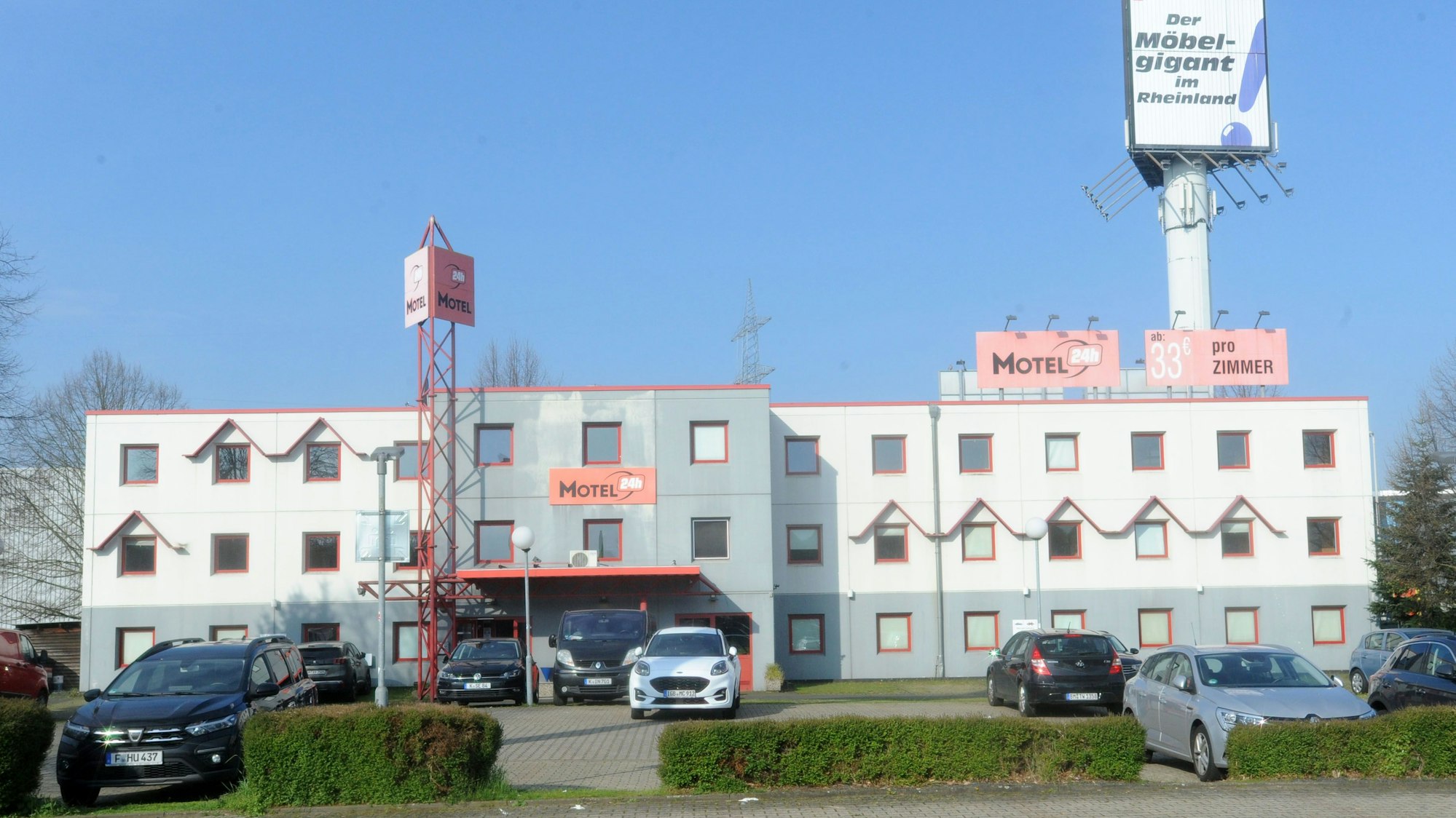 Auf dem Foto ist das Motel 24h an der Europaallee in Frechen zu sehen. Einige Autos sind davor geparkt.