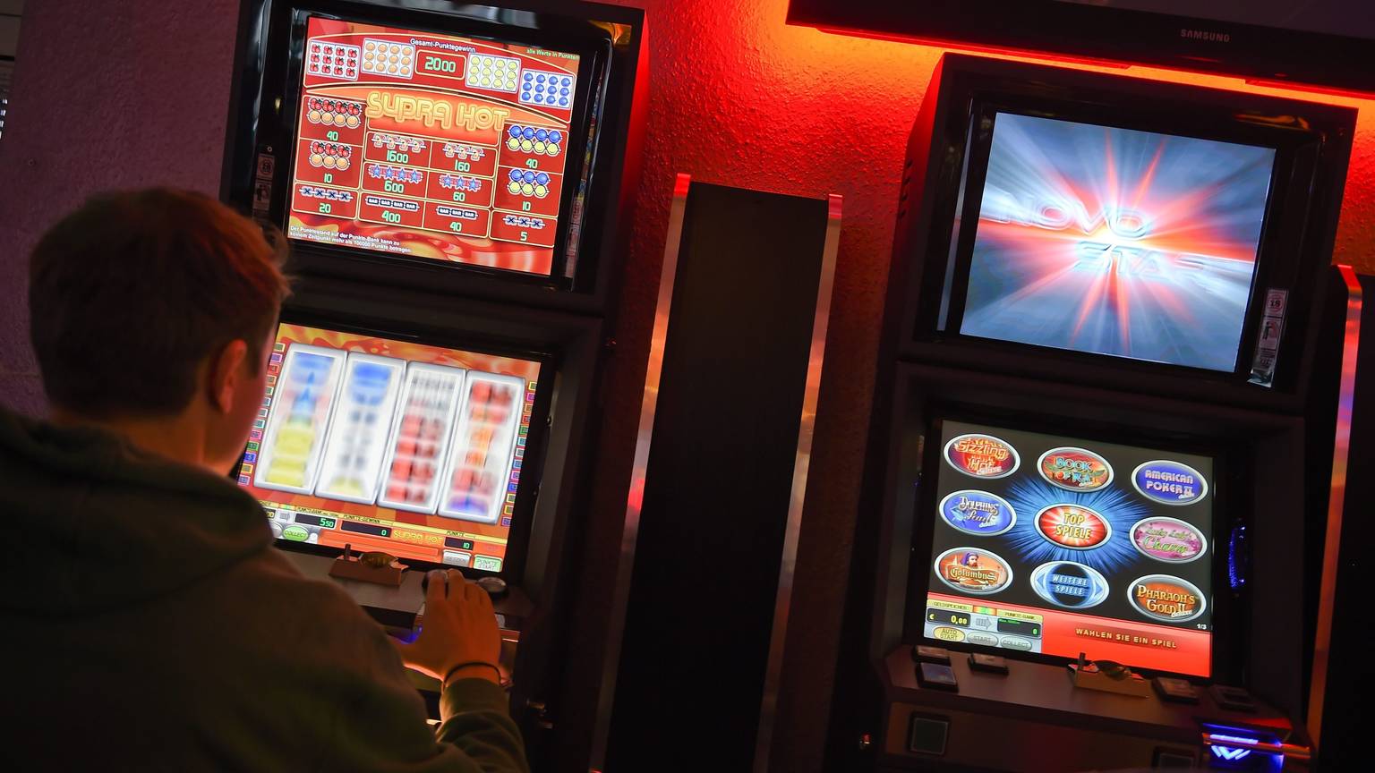 ARCHIV - 14.03.2015, Berlin: ILLUSTRATION - Ein junger Mann spielt an einem Spielautomaten.
