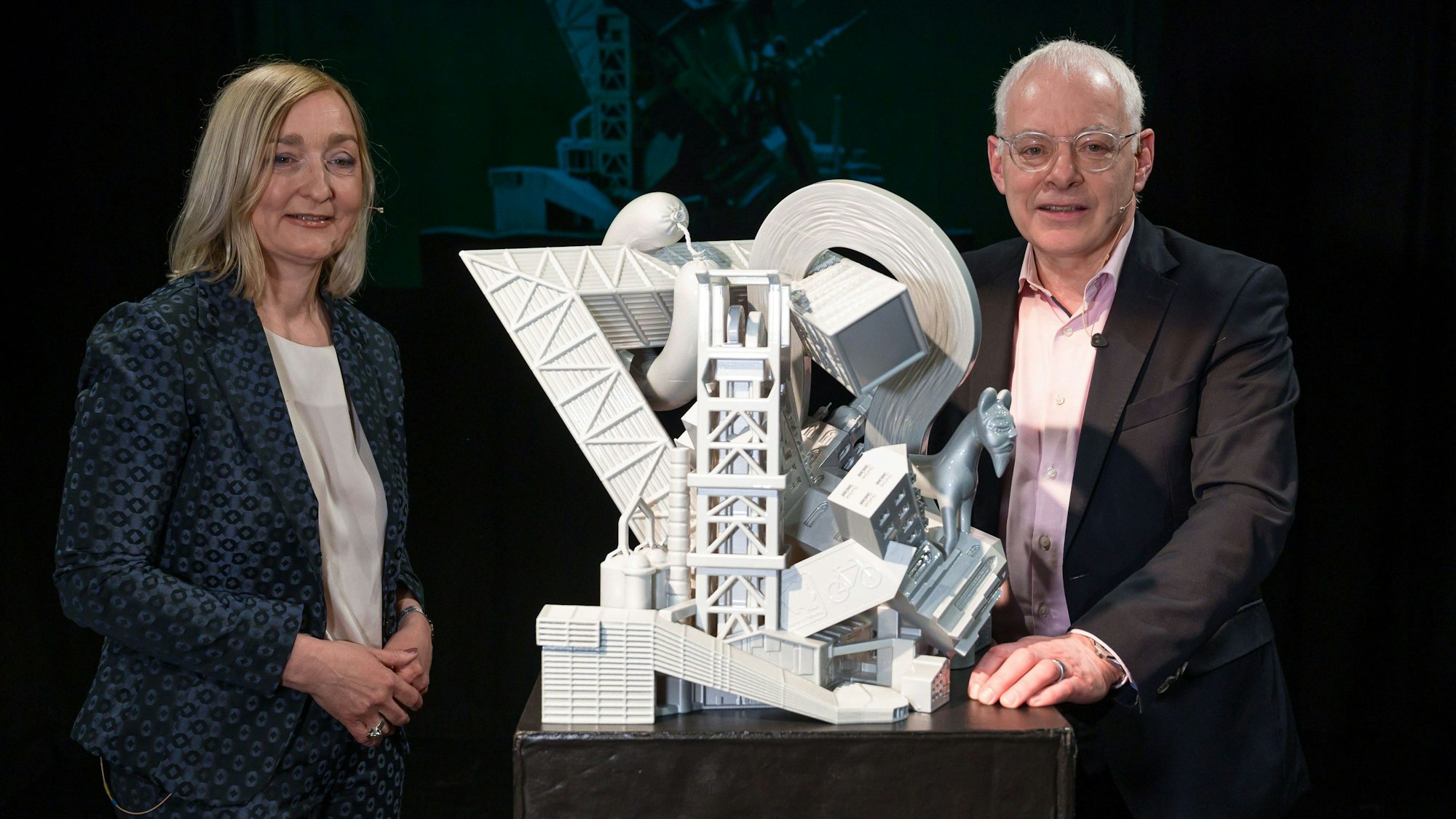 Birgit Grauvogel, Geschäftsführerin der Tourismus Zentrale Saarland, und der Wirtschaftsminister des Saarlandes, Jürgen Barke (SPD), stehen neben einem großen Modell des „Saarvenirs“.