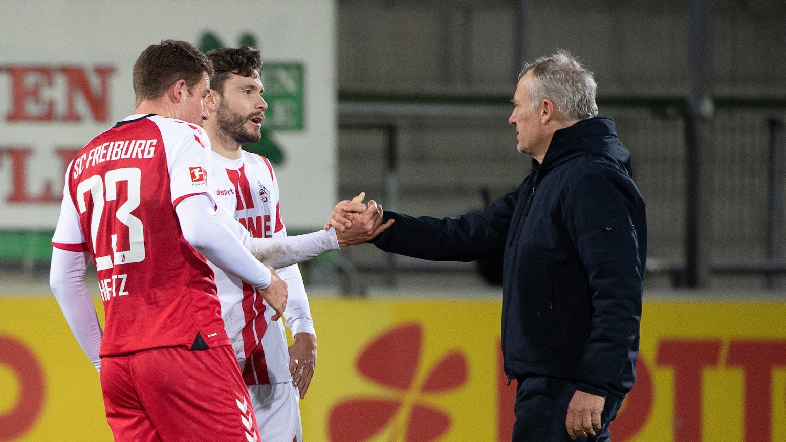 Fußball: Bundesliga, SC Freiburg - 1. FC Köln, 15. Spieltag, Schwarzwald-Stadion: Freiburgs Trainer Christian Streich (r) gibt Kölns Jonas Hector (M) nach dem Spiel die Hand. Nun lobte Streich den Kölner Hector, der sein Karriereende am Ende dieser Saison angekündigt hat. Foto: Sebastian Gollnow/dpa +++ dpa-Bildfunk +++