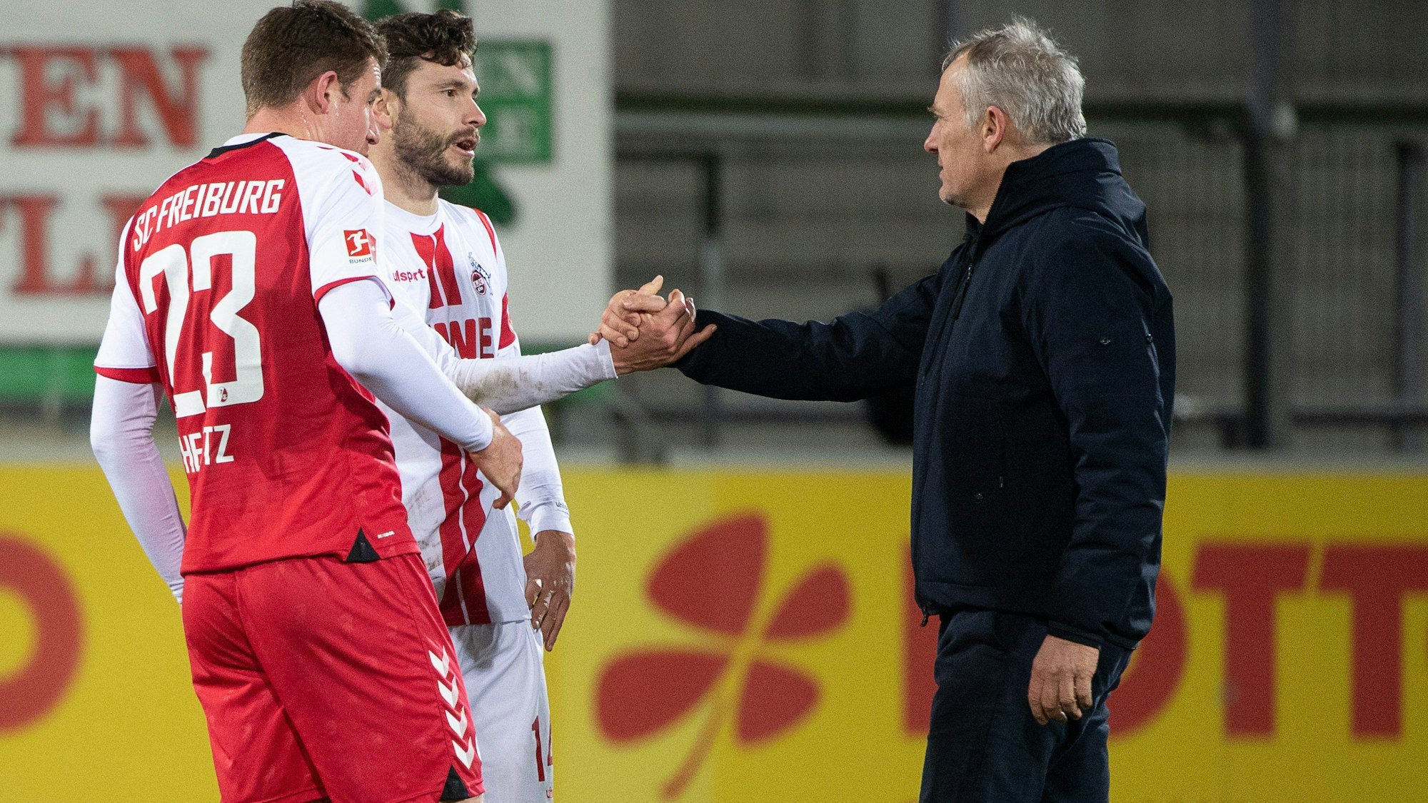 Fußball: Bundesliga, SC Freiburg - 1. FC Köln, 15. Spieltag, Schwarzwald-Stadion: Freiburgs Trainer Christian Streich (r) gibt Kölns Jonas Hector (M) nach dem Spiel die Hand. Nun lobte Streich den Kölner Hector, der sein Karriereende am Ende dieser Saison angekündigt hat. Foto: Sebastian Gollnow/dpa +++ dpa-Bildfunk +++