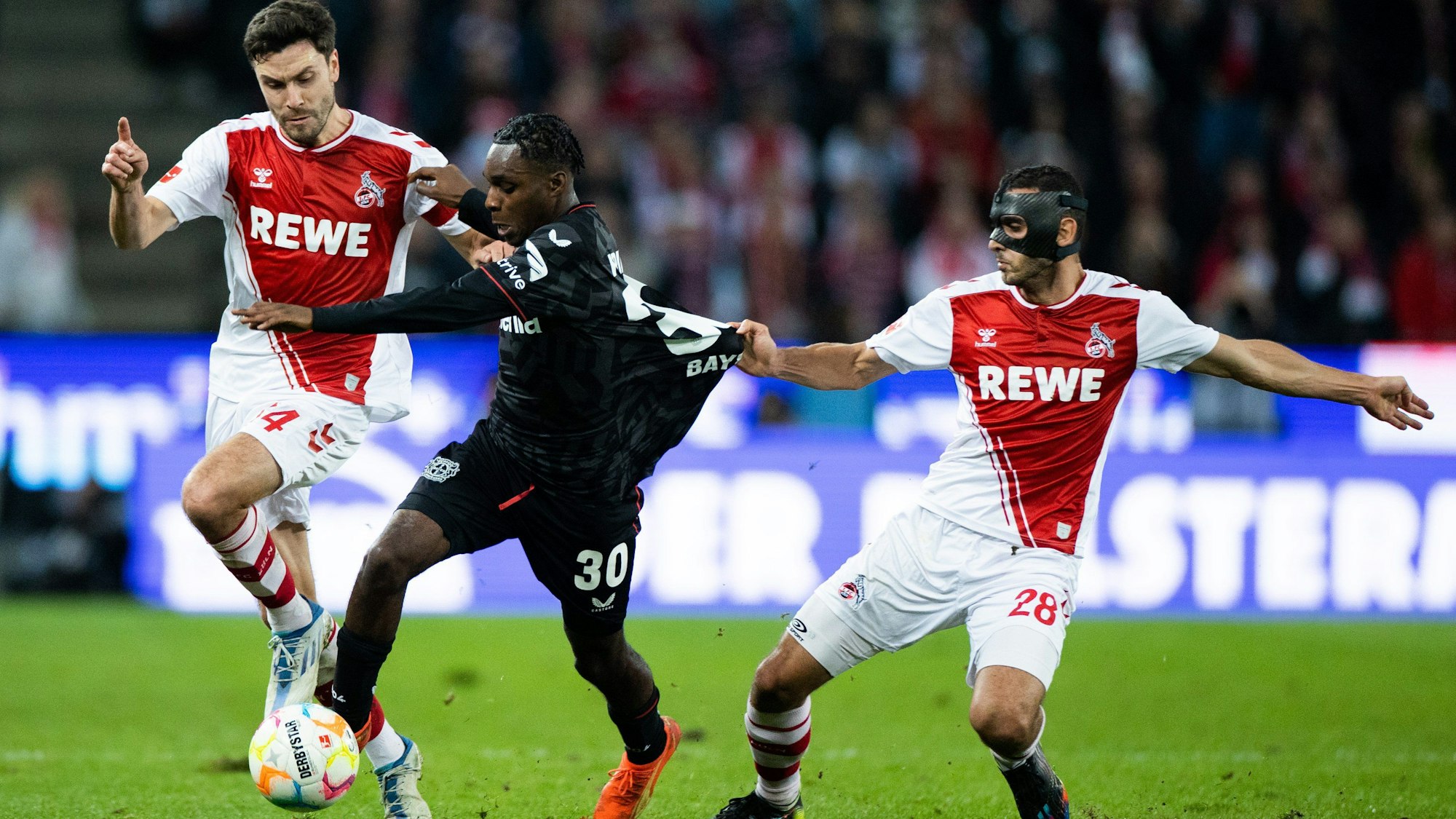 ARCHIV - 09.11.2022, Nordrhein-Westfalen, Köln: Fußball: Bundesliga, 1. FC Köln - Bayer Leverkusen, 14. Spieltag, RheinEnergieStadion. Kölns Jonas Hector (l) und Ellyes Skhiri (r) und Leverkusens Jeremie Frimpong versuchen an den Ball zu kommen.