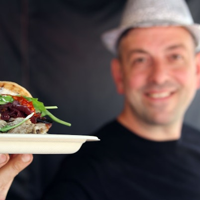 Ein Koch zeigt ein Spanferkelbraten im Focaccia-Brot. Beim Wesselinger Streetfood-Festival gehörte es im Jahr 2022 gehörte es zu den Top-Angeboten. Auch in Bedburg soll es kulinarisch abwechslungsreich zugehen.