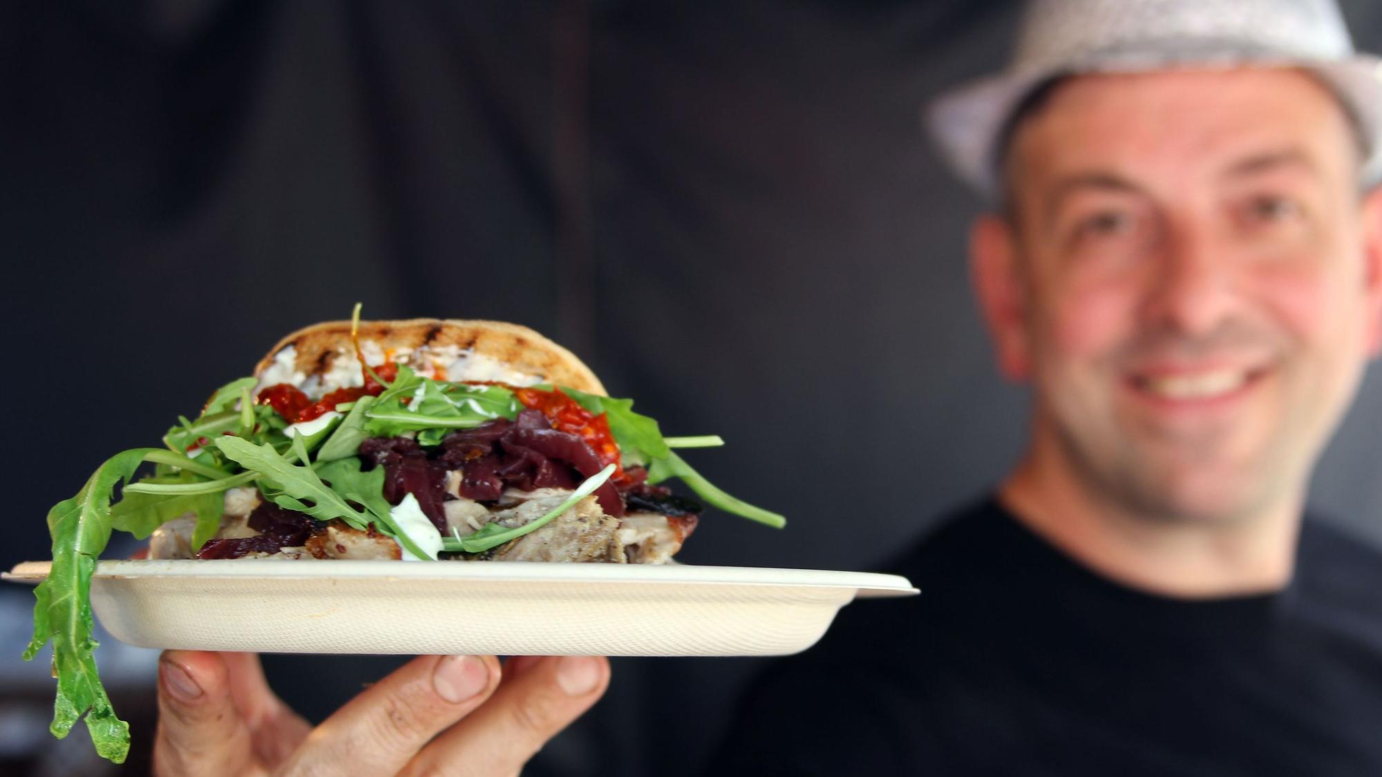 Ein Koch zeigt ein Spanferkelbraten im Focaccia-Brot. Beim Wesselinger Streetfood-Festival gehörte es im Jahr 2022 gehörte es zu den Top-Angeboten. Auch in Bedburg soll es kulinarisch abwechslungsreich zugehen.