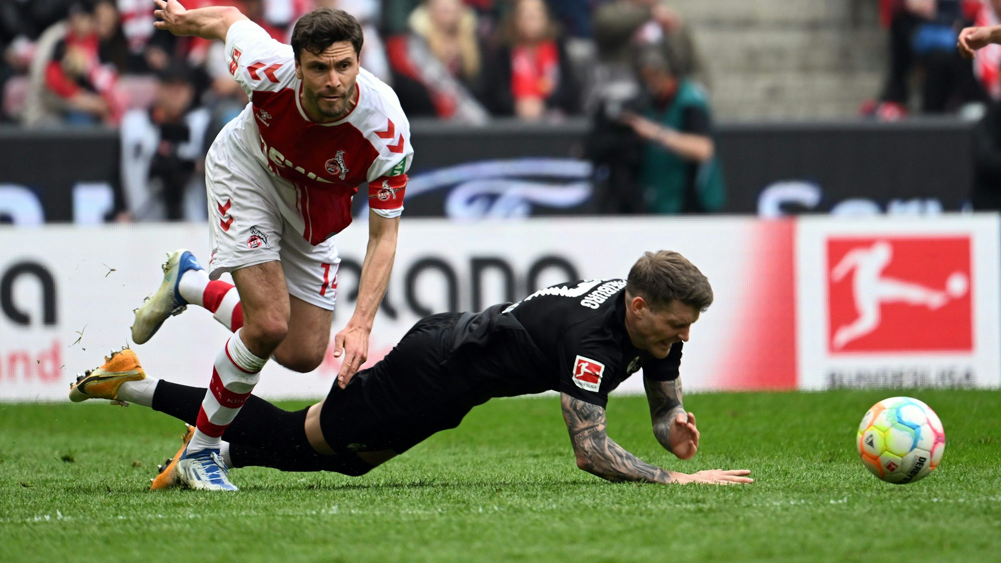 Kölns Jonas Hector (l) und Freiburgs Lukas Kübler kämpfen um den Ball.