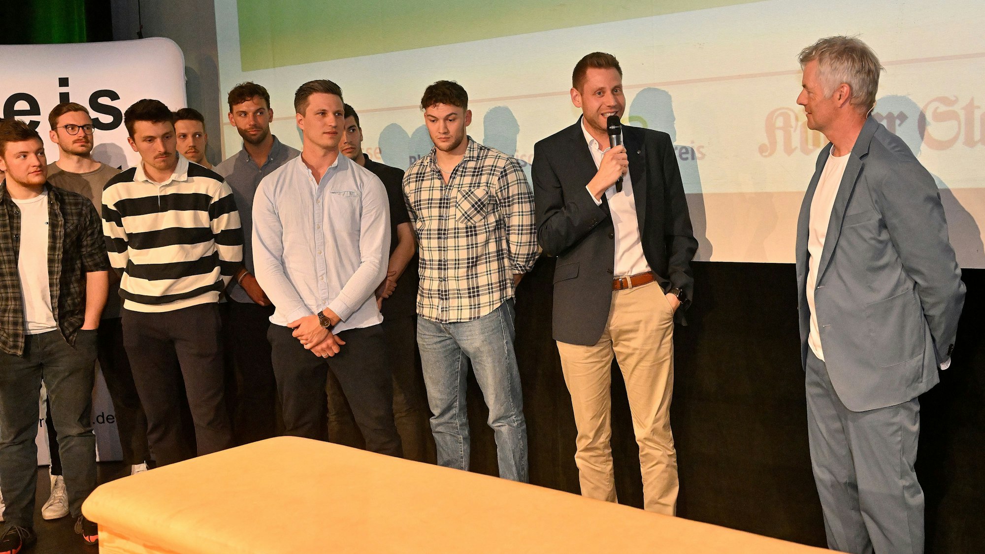 Eine Gruppe von Männern steht hinter einem Kasten auf der Bühne der Sportlerehrung 2022 im Bergischen Löwen.