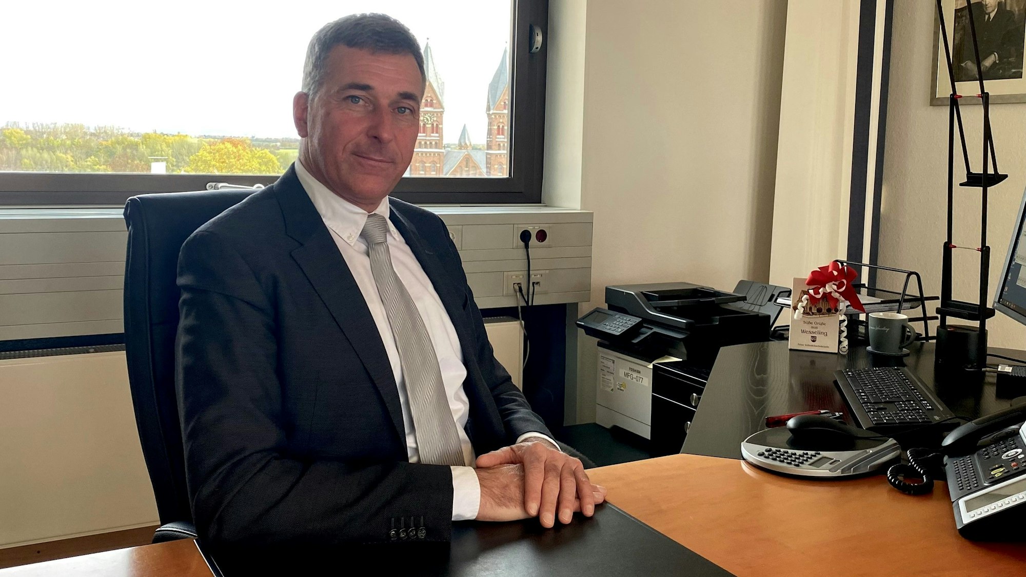 Ralph Manzke sitzt an einem Schreibtisch.