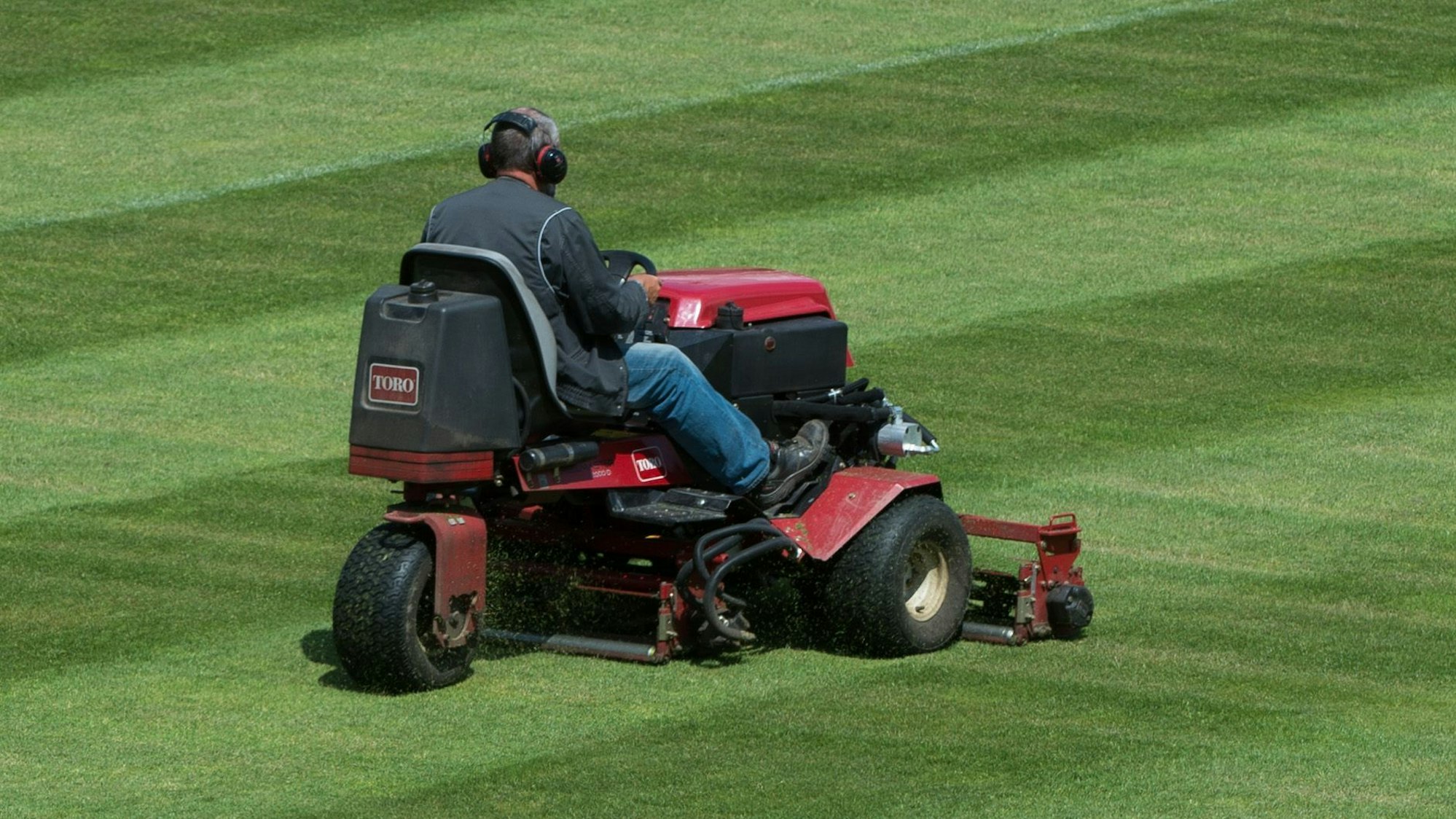 Ein Mann fährt am 21.07.2015 im Steigerwaldstadion in Erfurt (Thüringen) mit einem Aufsitzrasenmäher über das Spielfeld.