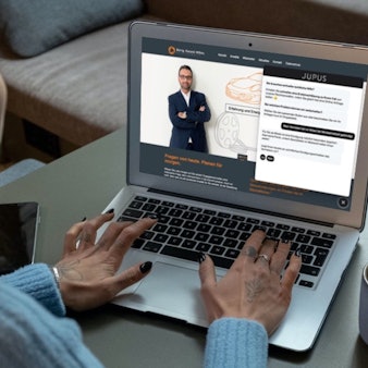 Eine Frau sitzt vor einem Laptop.