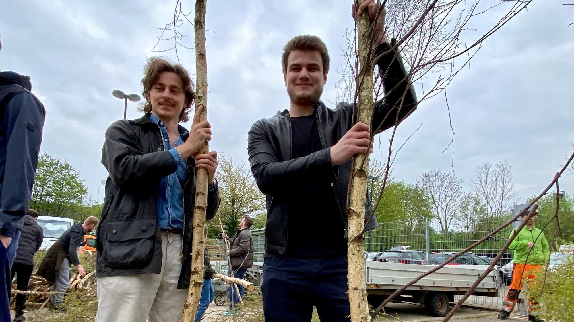 Jonas Schmidt (l.) und Bencan Torgut (r.) posieren mit ihren Maibäumen.