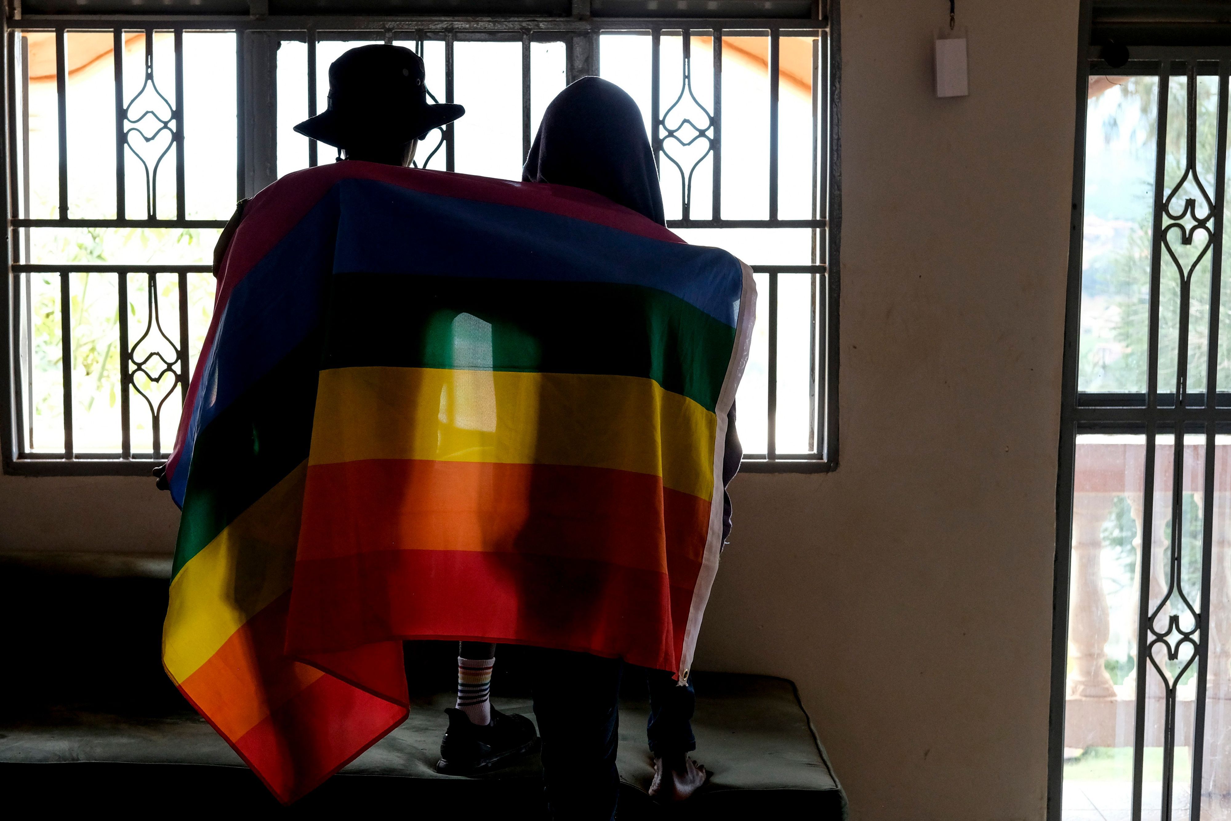 Ein schwules ugandisches Paar bedeckt sich mit einer Stolzflagge und posiert für ein Foto in Uganda am 25. März 2023.