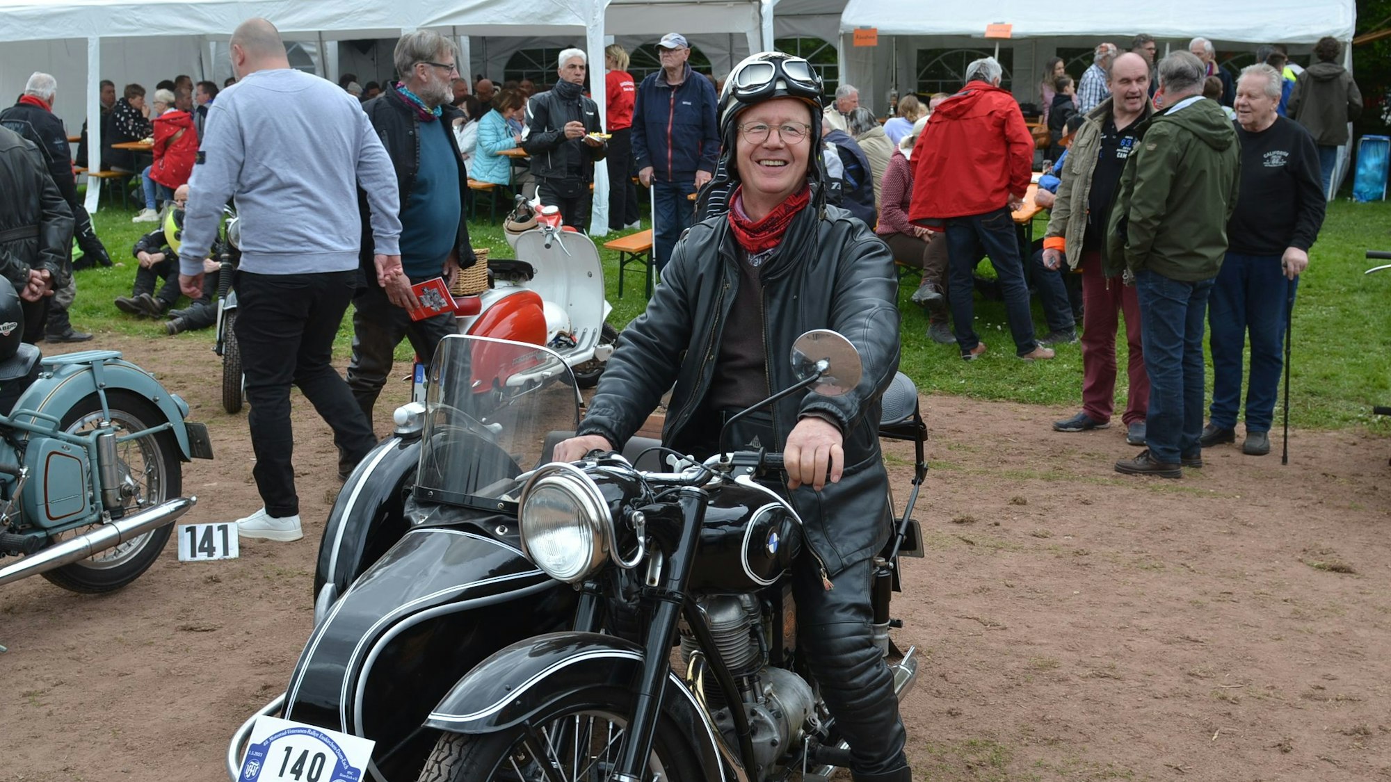Es ist Hubert Frisch auf seinem Motorrad zu sehen.