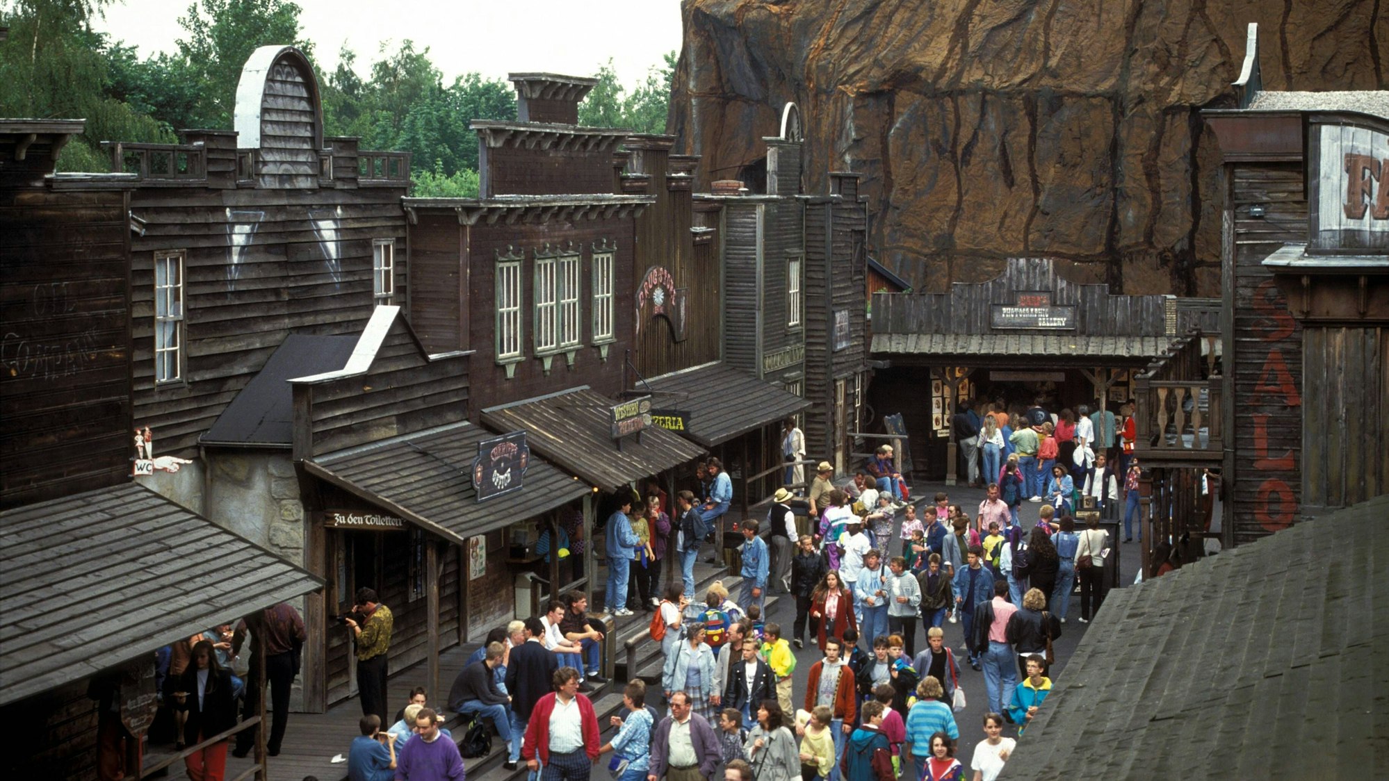 Freizeitpark-Gäste strömen im Juni 1991 durch die Westernstadt im Phantasialand.