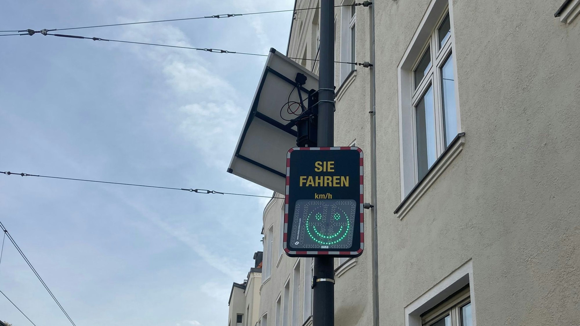 Eine digitale Geschwindigkeitsanzeige mit Smiley-Symbol.