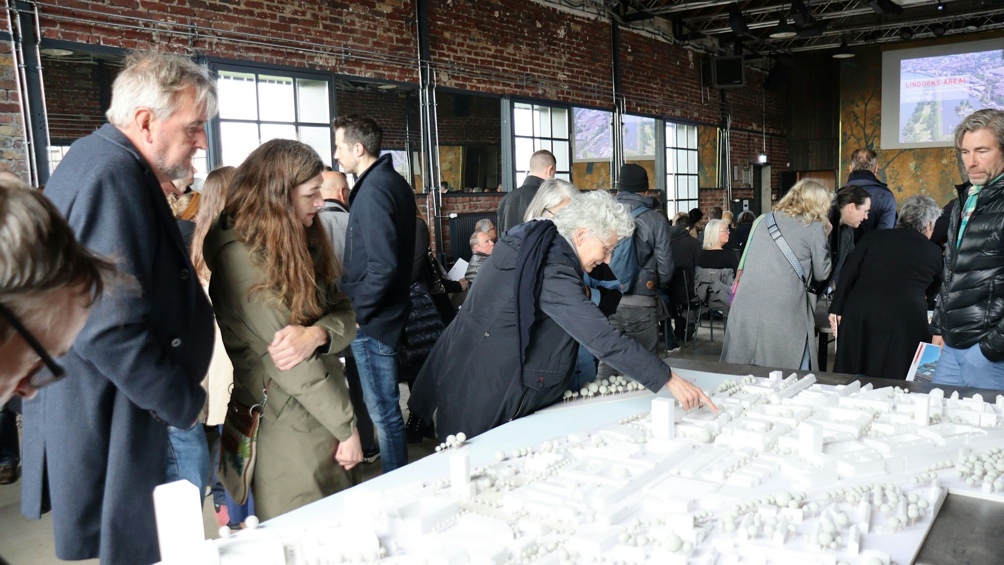 Einige Menschen sind um ein Modell des Lingens-Areals versammelt.