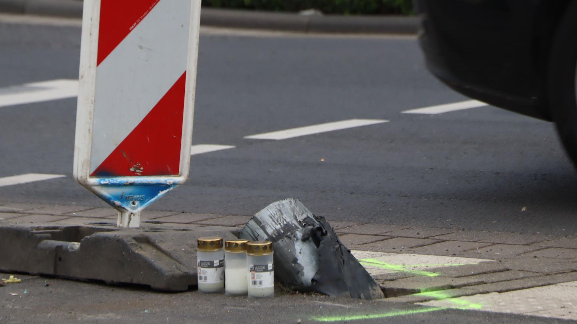 Das Foto zeigt die Unfallstelle in Hürth. An den abgesägten Ampelmast sind Kerzen aufgestellt worden.