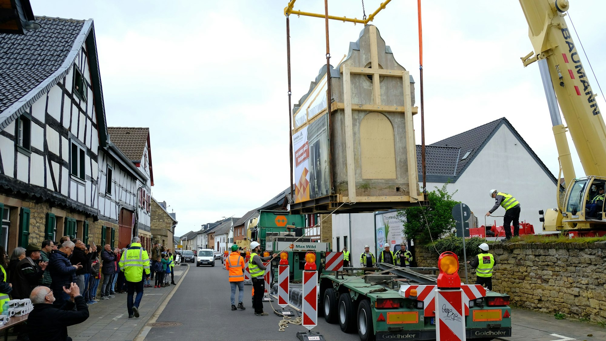 Das alte Trafohäuschen aus dem Jahr 1904 wird am Stück von Bürvenich ins Kommerner Freilichtmuseum transloziert. Ein Kran hievt das Gebäude auf einen Schwertransporter.