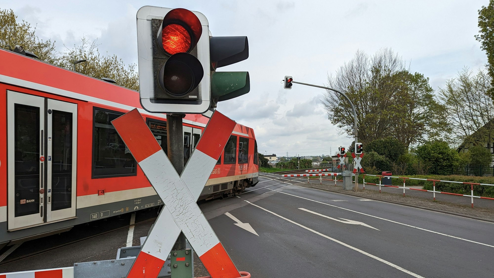 Das Foto zeigt, wie eine Bahn den Übergang in Hürth-Fischenich passiert. Die Schranken sind geschlossen.