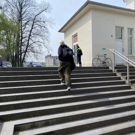 Eine Frau geht auf der Treppe am Bahnhof Brühl. Die Treppe wird abgerissen und durch eine Rampe ersetzt, damit die Züge barrierefrei erreichbar sind.