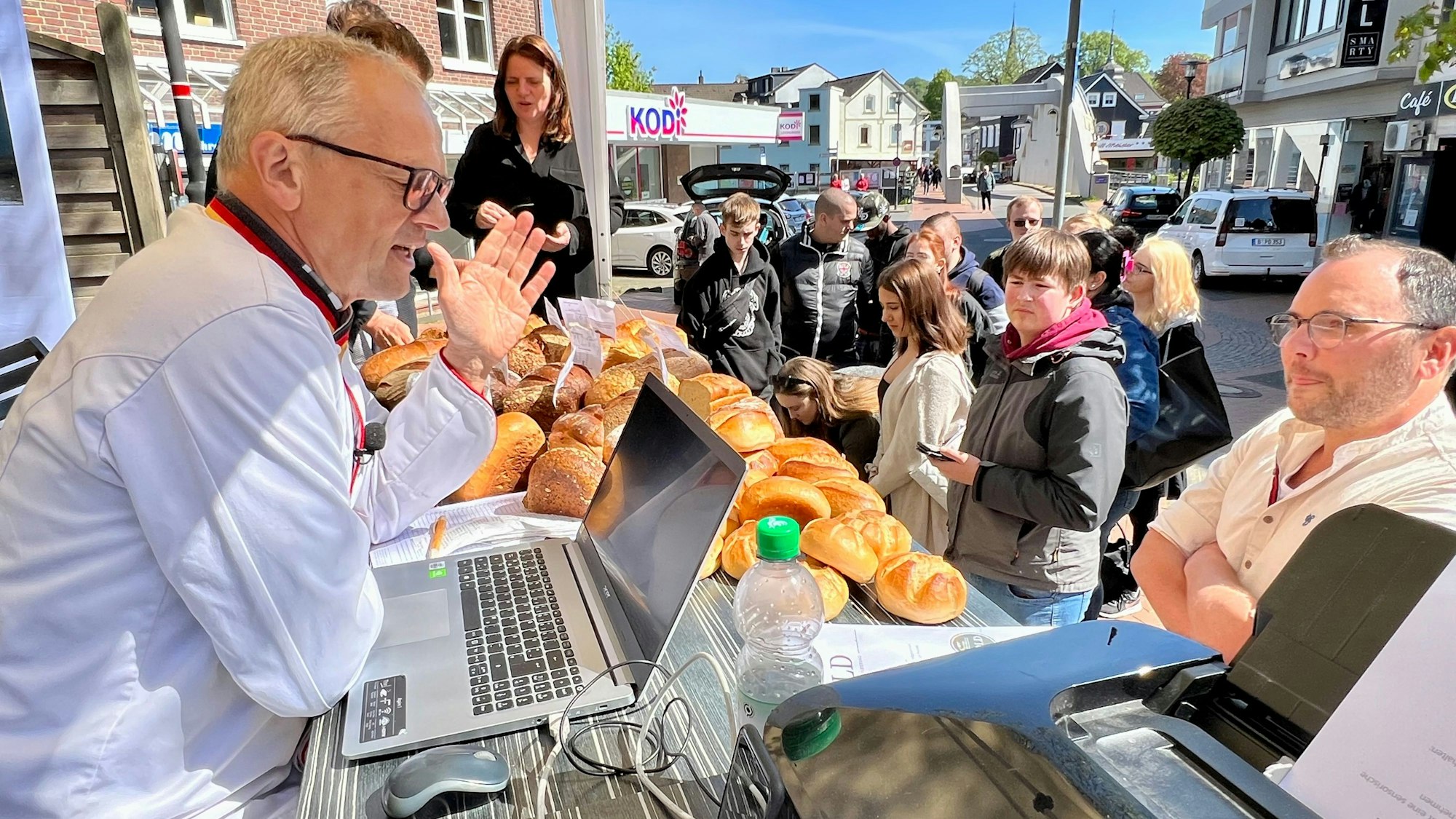Brotprüfer Karl-Ernst Schmalz vom Deutschen Brotinstitut erläutert vor der Bäckerei Willeke in Leichlingen seine Arbeit