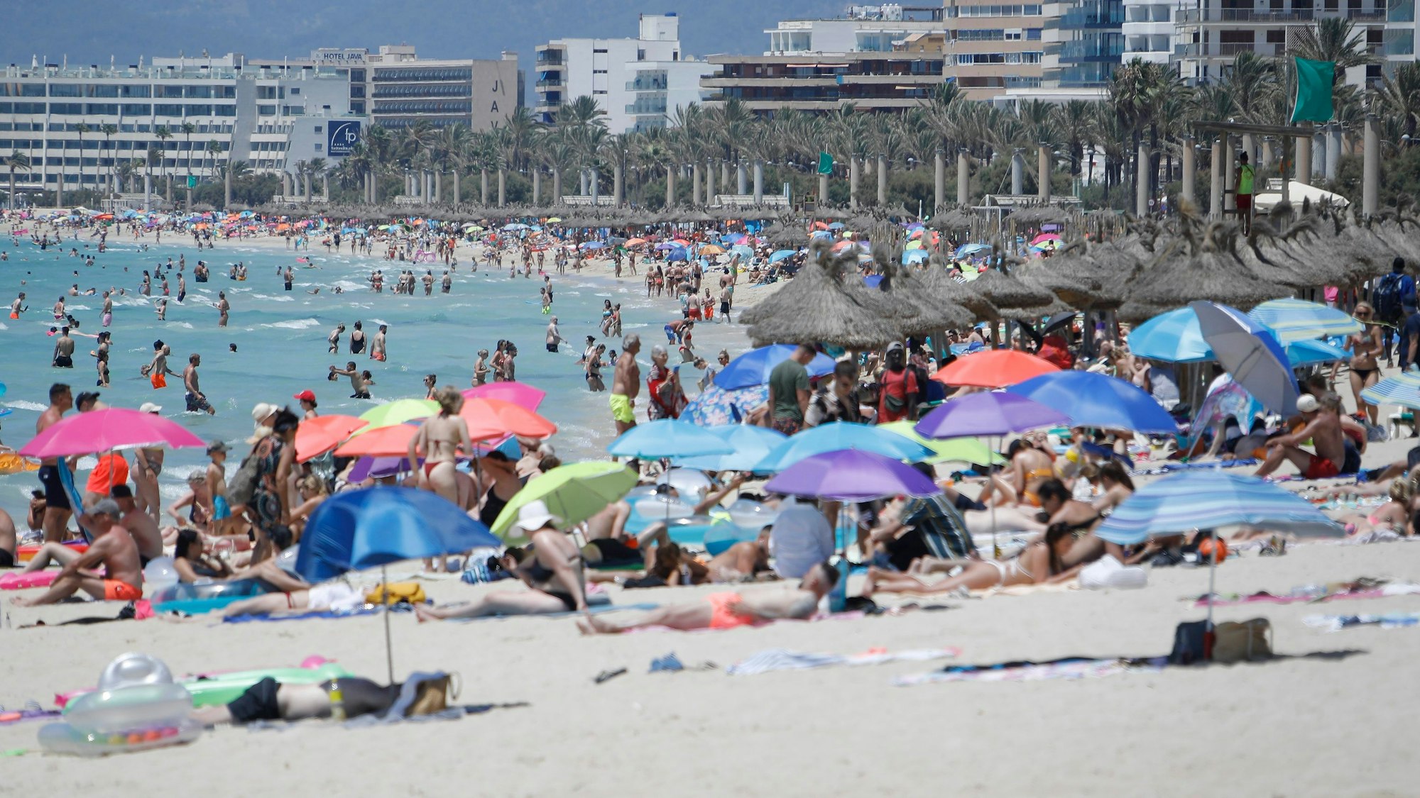 ARCHIV - 09.07.2021, Spanien, Palma de Mallorca: Touristen genießen die Sonne am Strand von Arenal.