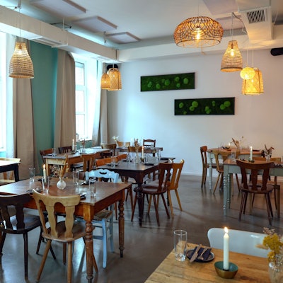 Holztische und -stühle mit Blumen und Kerzen in einem Restaurant