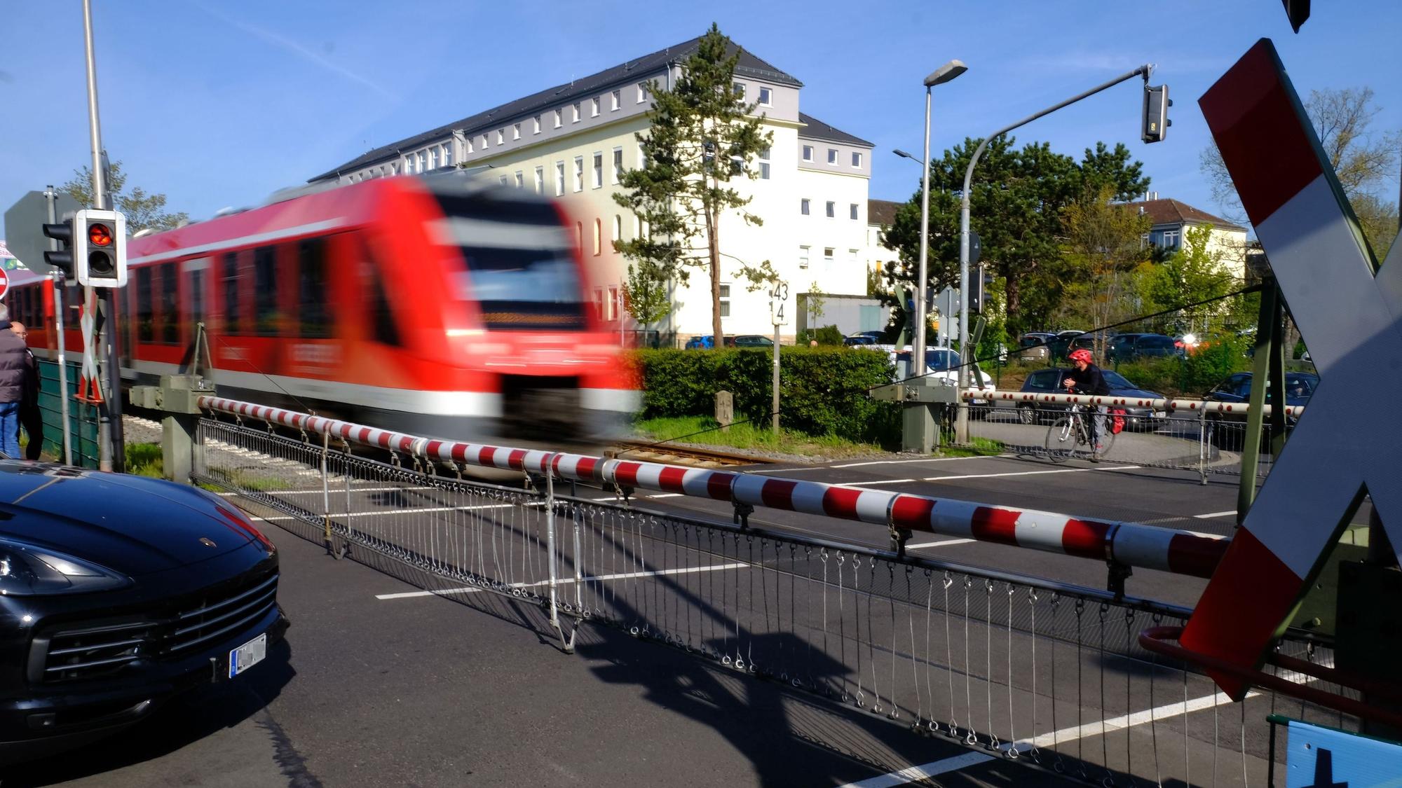 An den geschlossenen Bahnschranken (wie hier am Bahnübergang in der Weierstraße in der Nähe des Krankenhauses, im Hintergrund) stauen sich die Fahrzeuge.
