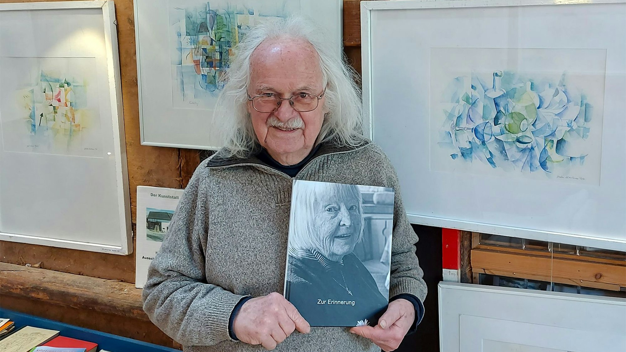 Ein Mann hält ein Porträt in die Kamera.