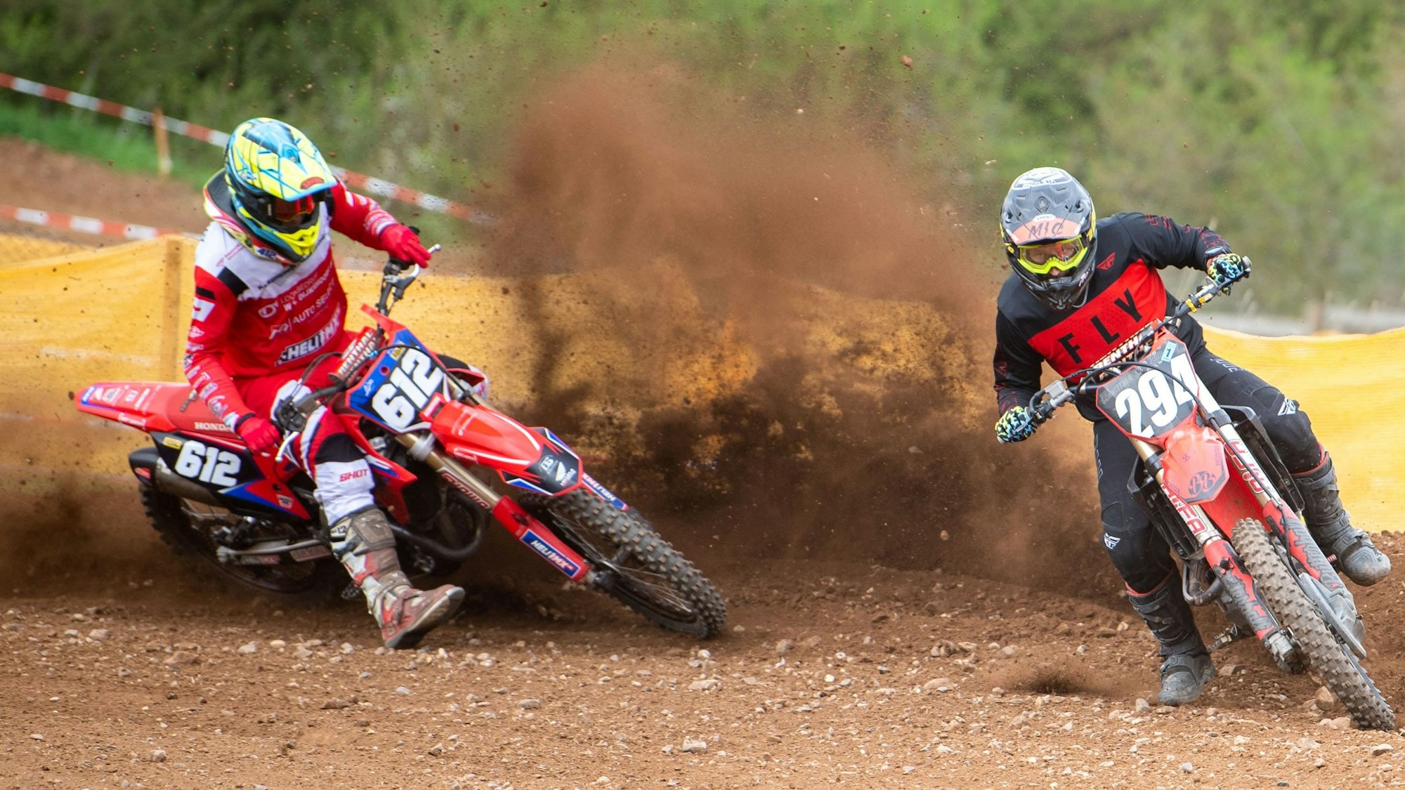 Zwei Motocross-Fahrer auf der Rennstrecke.