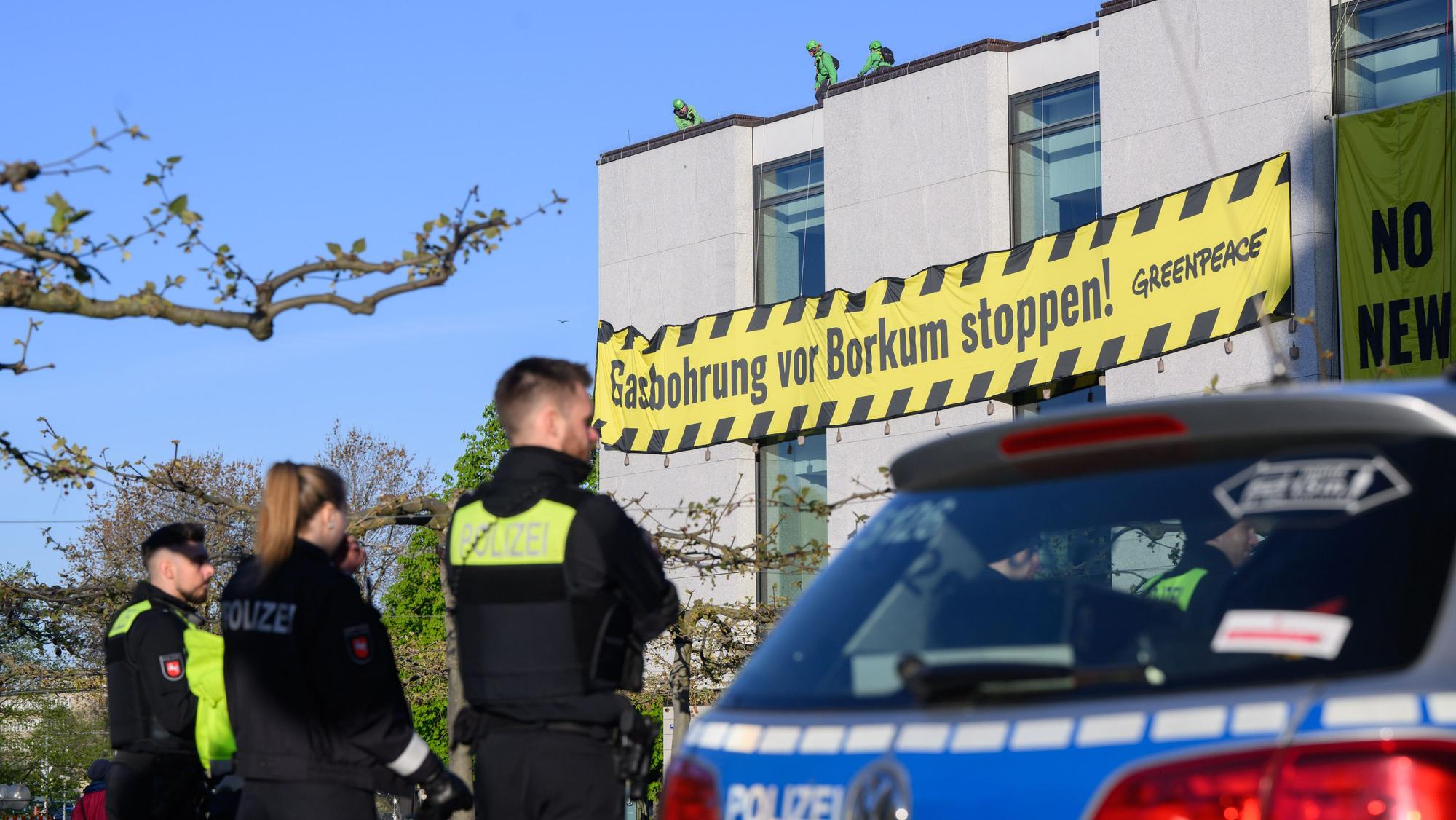 Polizisten beobachten, wie Aktivisten der Umweltschutzorganisation Greenpeace am frühen Morgen Banner an der Fassade des niedersächsischen Landtages befestigen. Greenpeace protestiert gegen eine Gasbohrung vor der Nordseeinsel Borkum.
