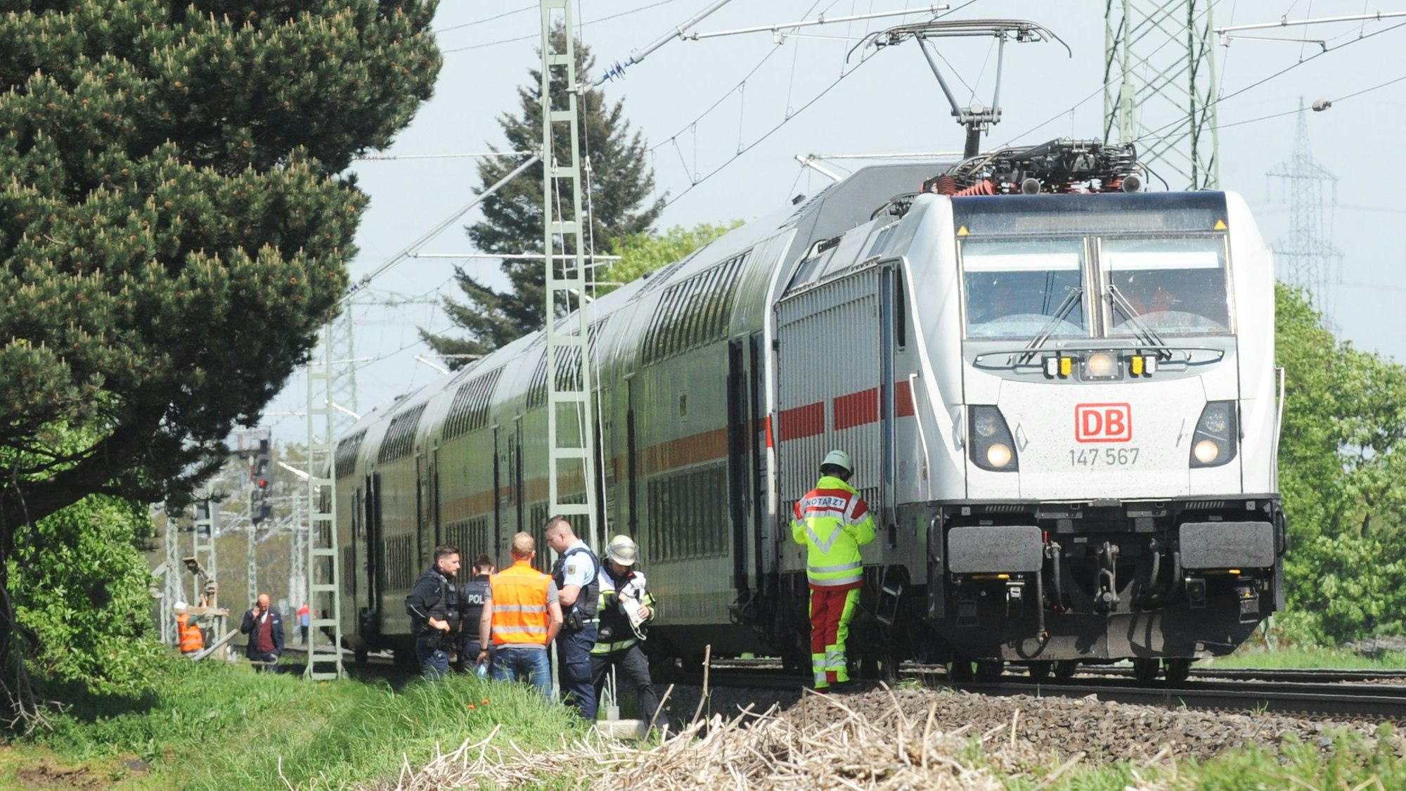 Das Bild zeigt einen stehenden Zug und mehrere Rettungskräfte.
