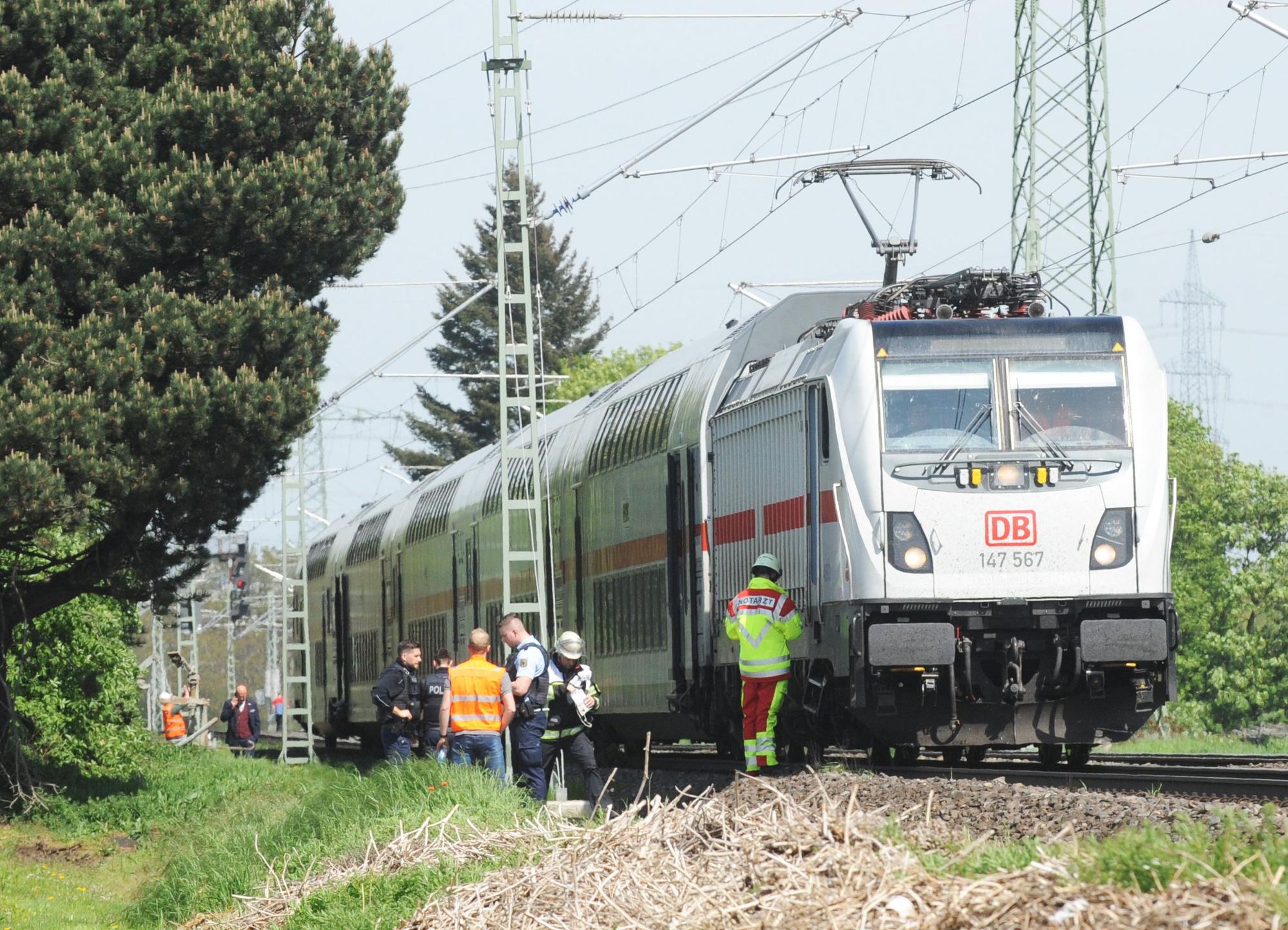 Das Bild zeigt einen stehen Zug und Mitarbeiter des Rettungsdienstes.