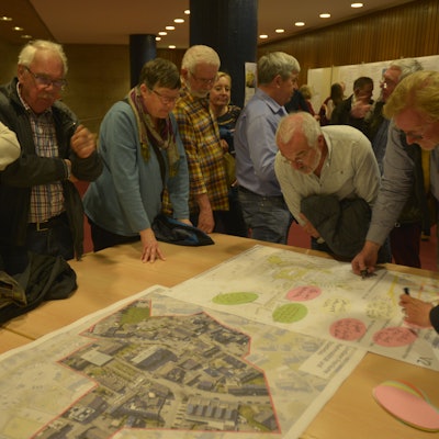 Bürger beraten bei der Bürgerbeteiligung zum Stadtentwicklungsprogramm Isek in einem Workshop über Pläne.