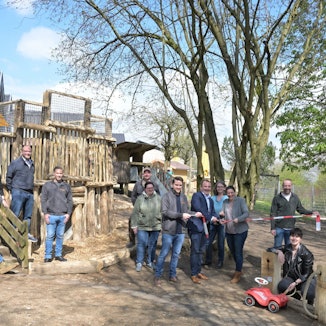 Es sind einige Mitglieder auf dem Außengelände zu sehen.