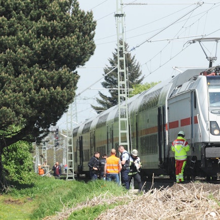 Das Bild zeigt Beamte der Bahnpolizei und Rettungskräfte am Zug.