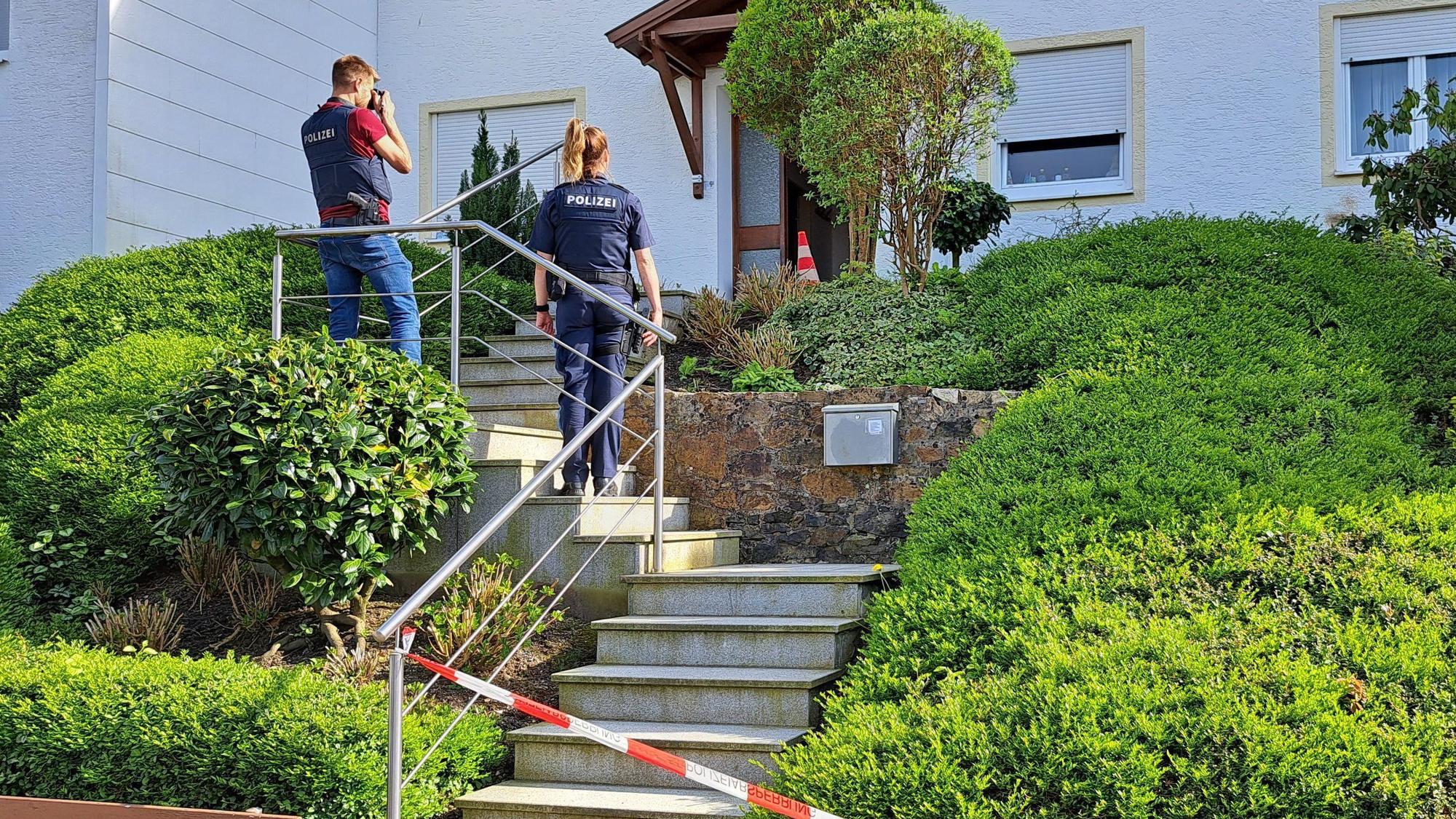04.05.2023, Bayern, Passau: Polizisten sichern Spuren und fotografieren vor einem Haus in einer Wohnsiedlung in Passau.