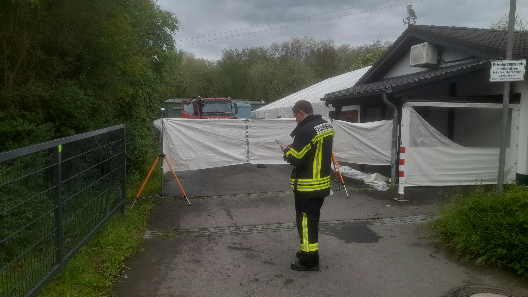 Ein Feuerwehrmann steht vor einer Sichtschutzplane.
